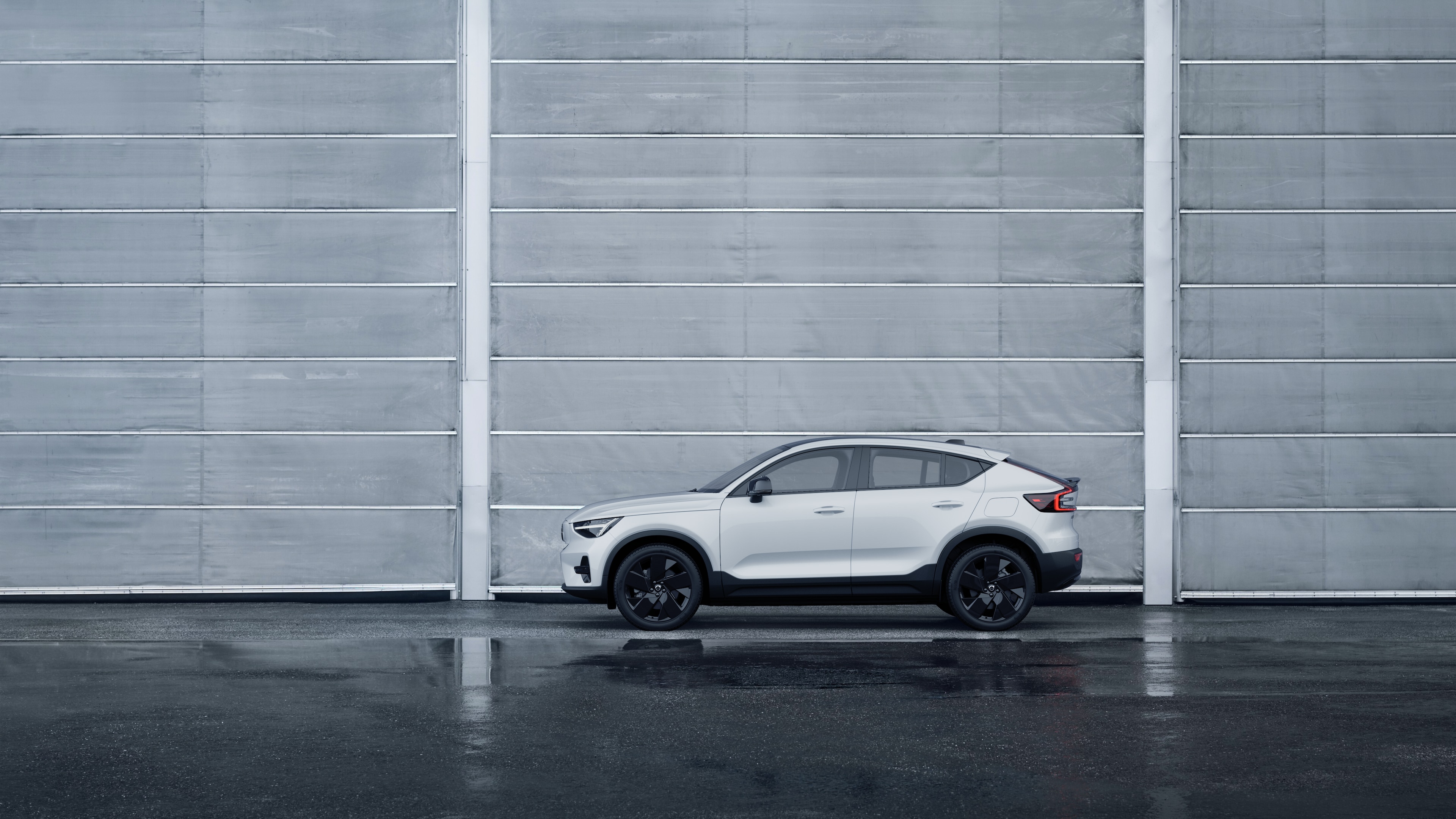 Volvo Fahrzeug, Seitenansicht, geparkt vor einer schlichten Betonwand.