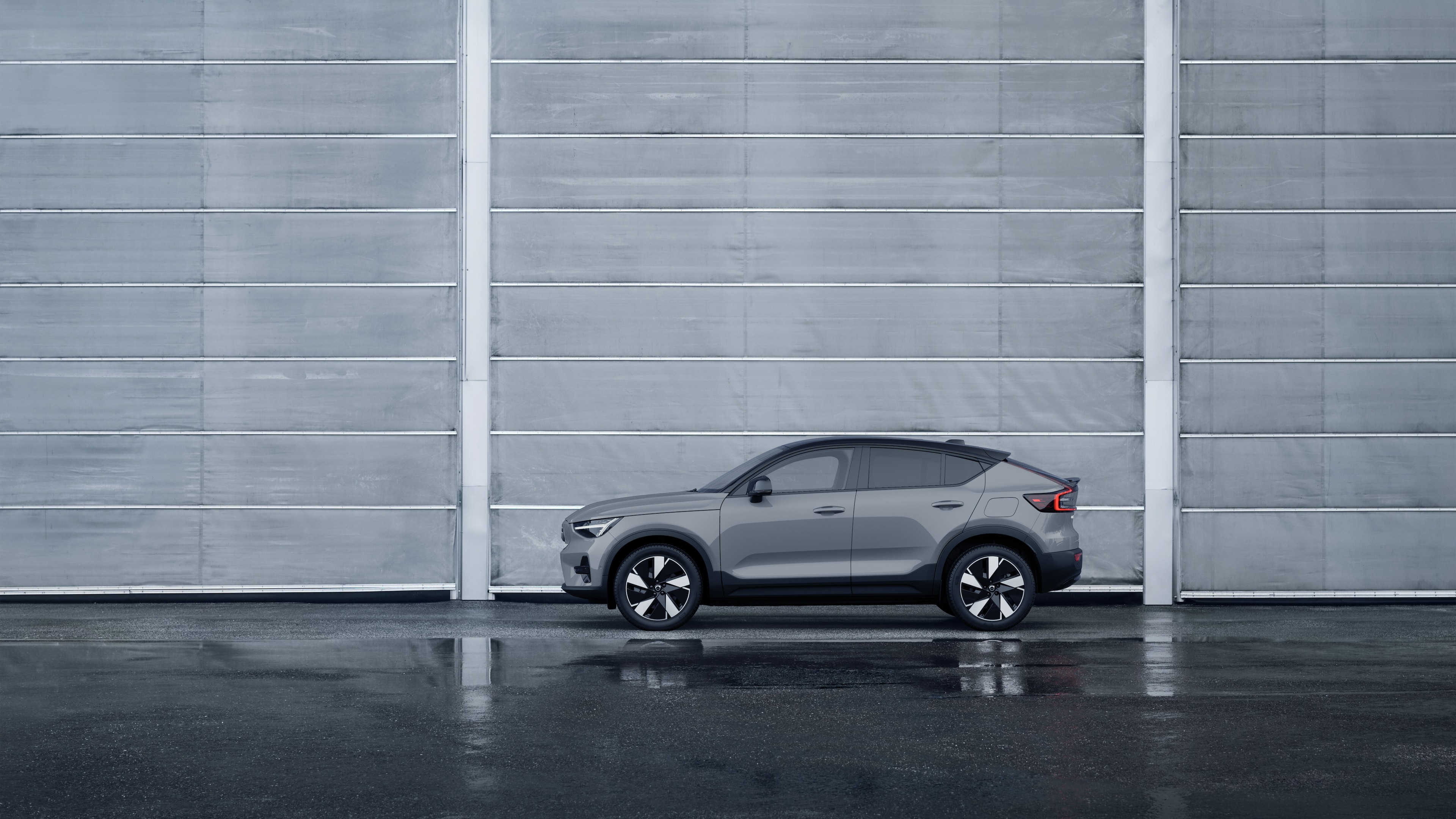 Voiture Volvo, vue latérale, garée sur un fond de mur en béton.