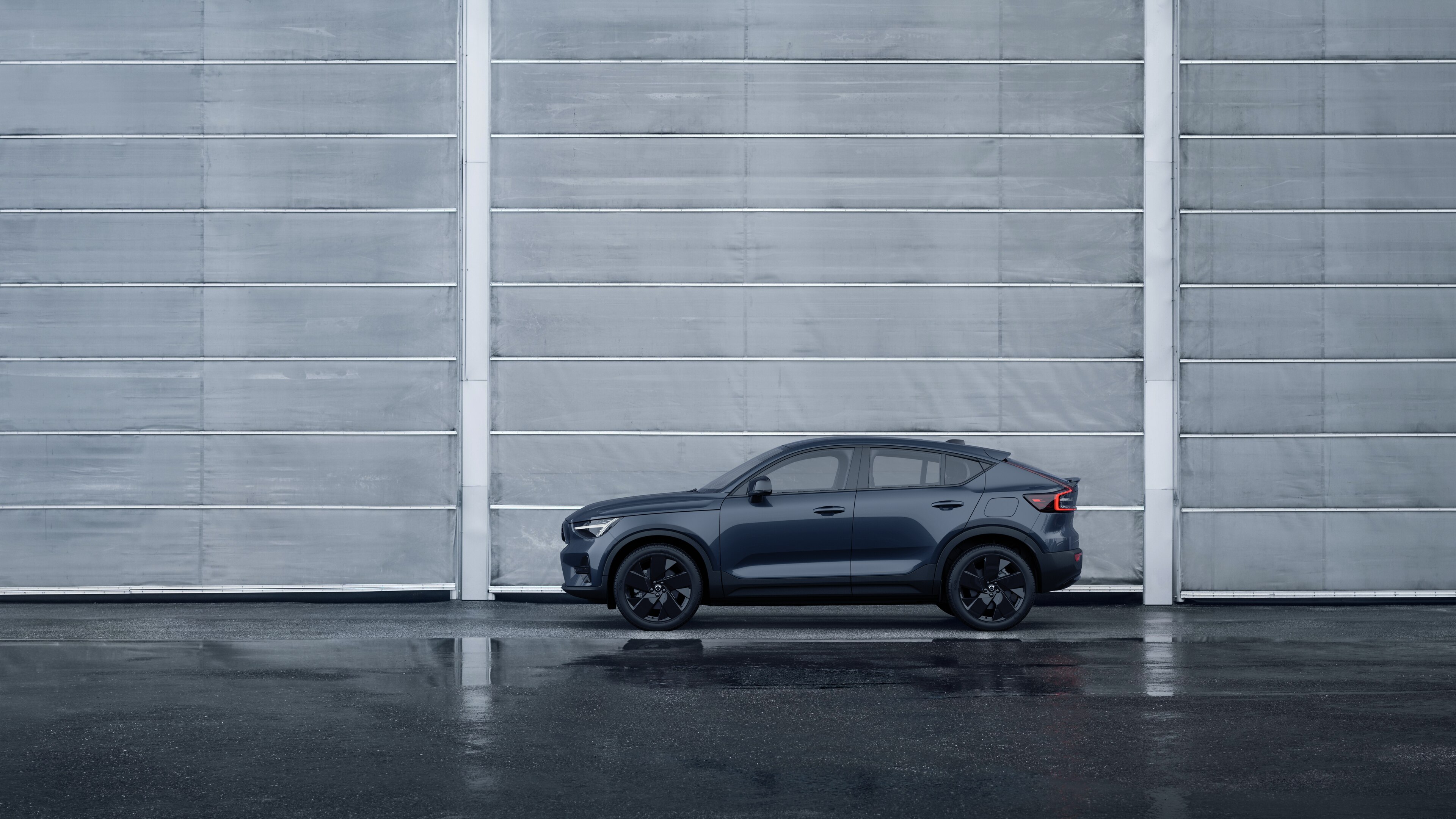 Volvo Fahrzeug, Seitenansicht, geparkt vor einer schlichten Betonwand.