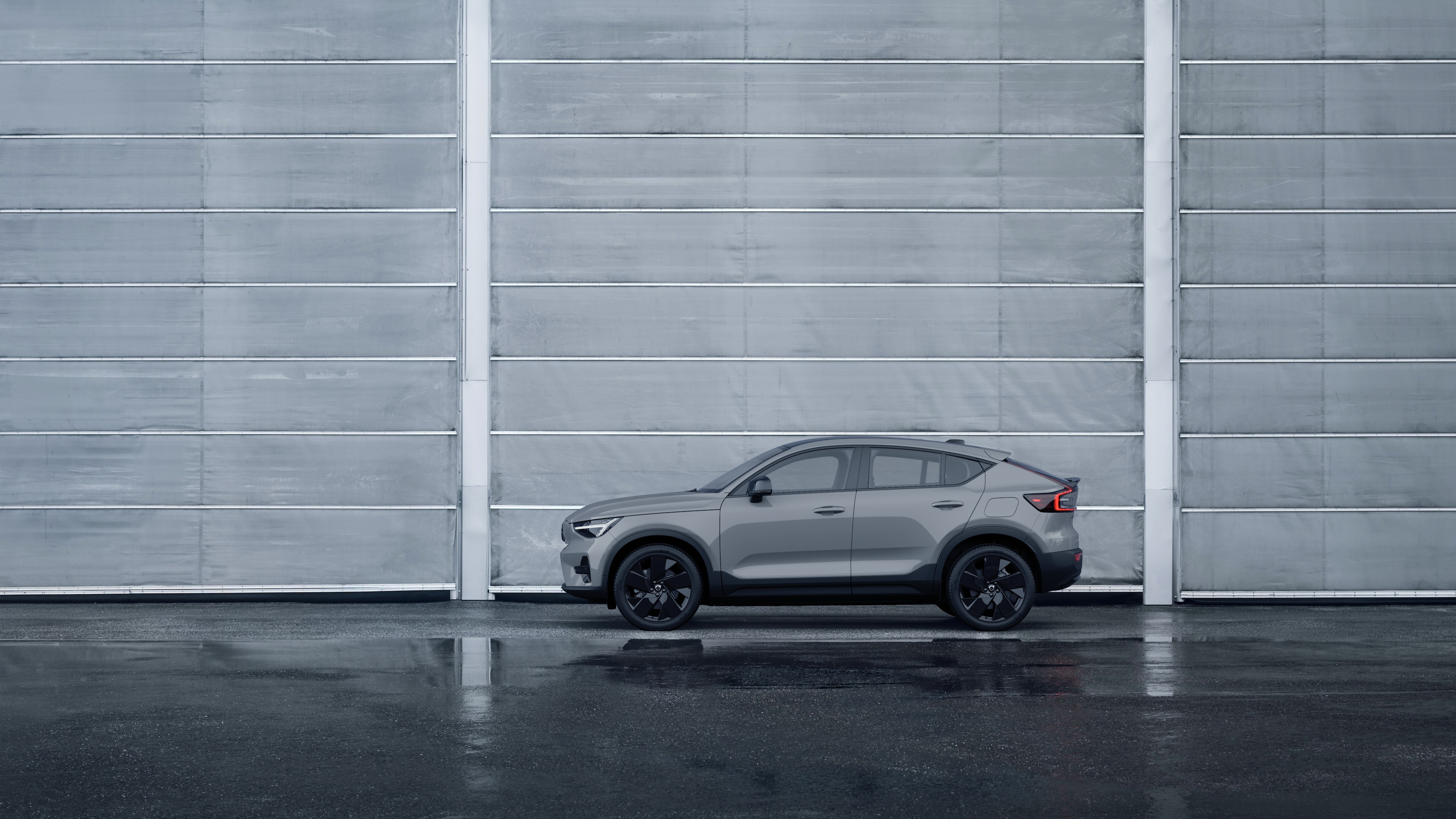 Volvo Fahrzeug, Seitenansicht, geparkt vor einer schlichten Betonwand.