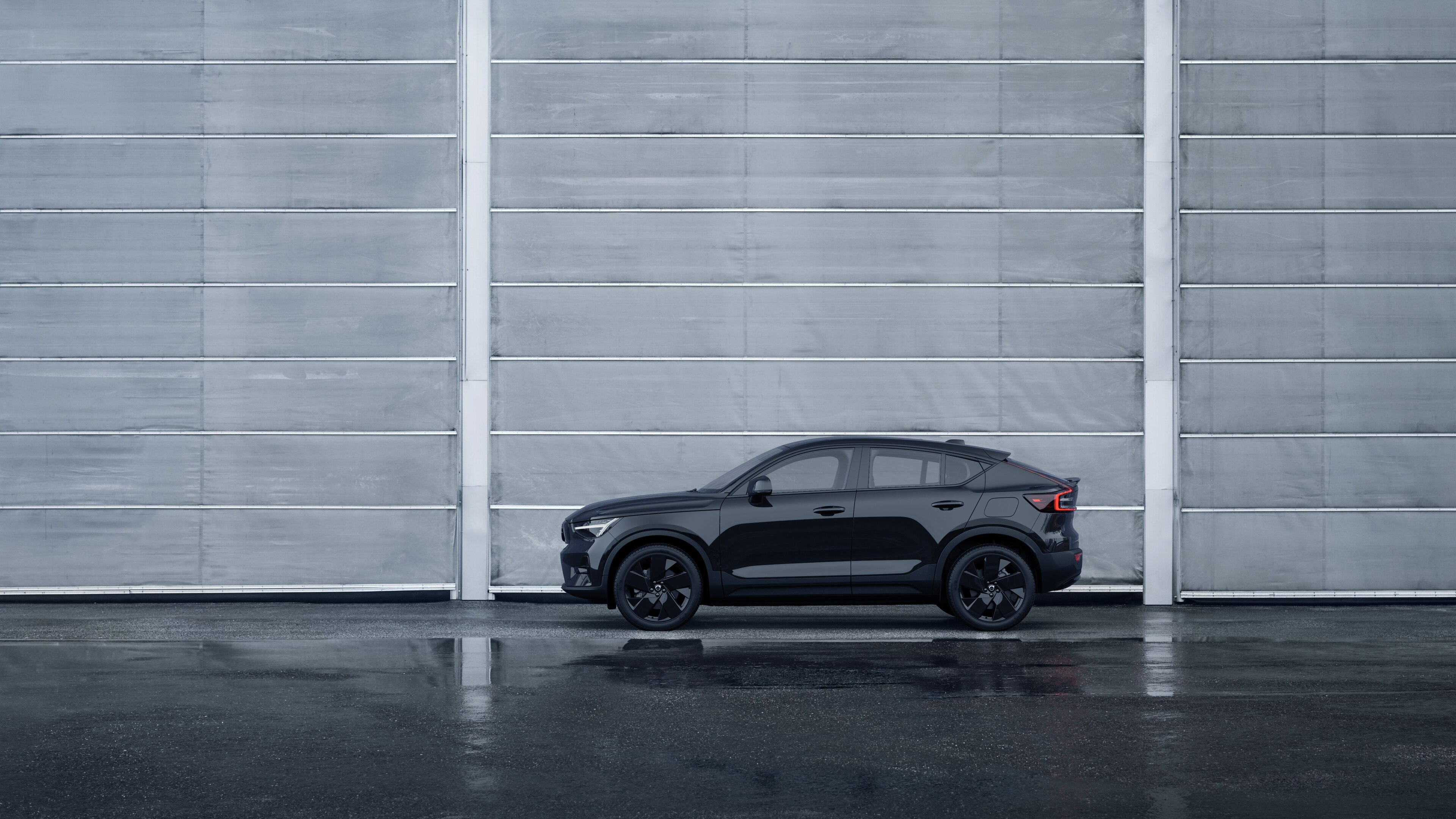 Volvo, sedd från sidan, parkerad mot en enkel betongvägg.