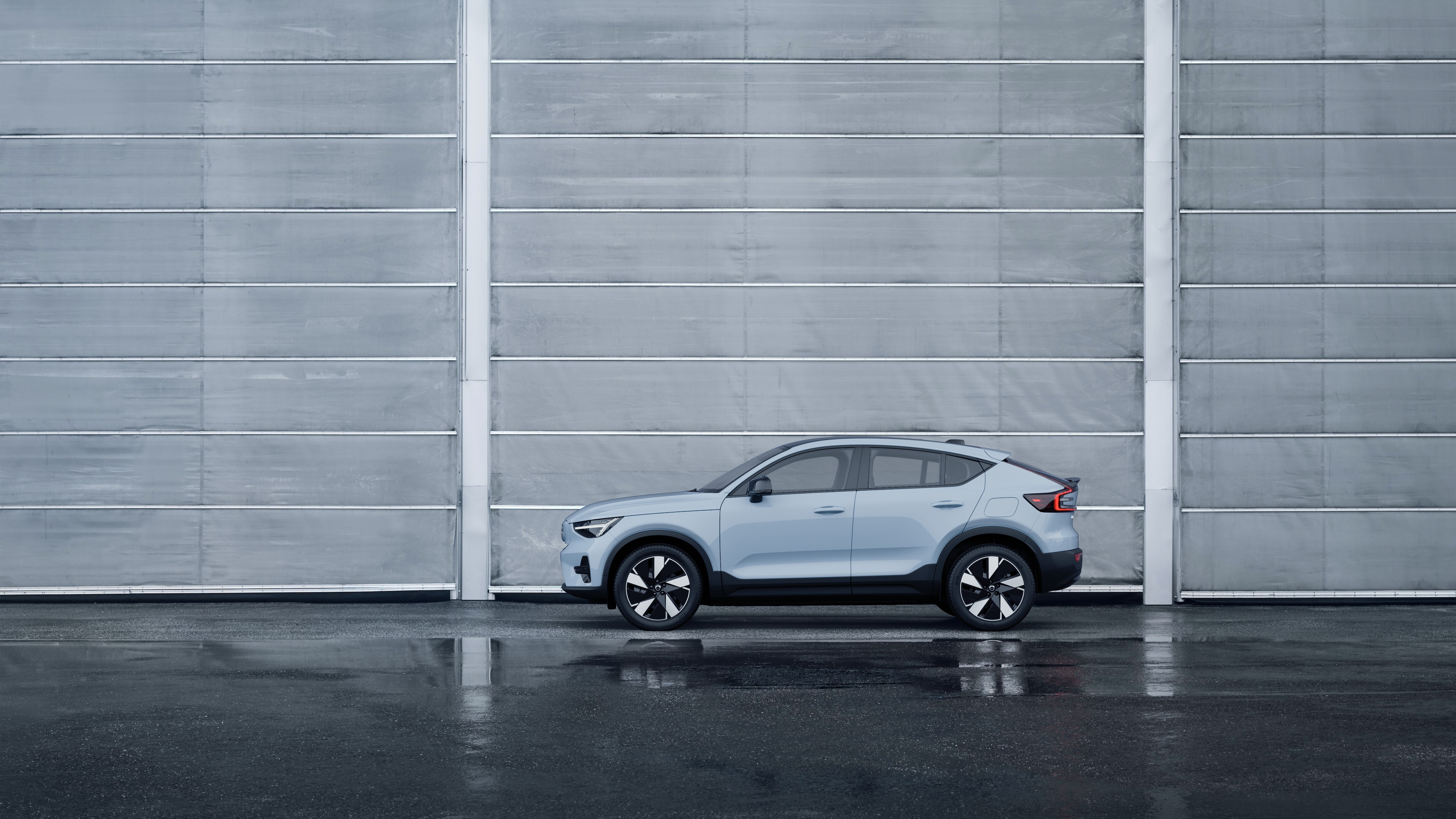 Volvo Fahrzeug, Seitenansicht, geparkt vor einer schlichten Betonwand.
