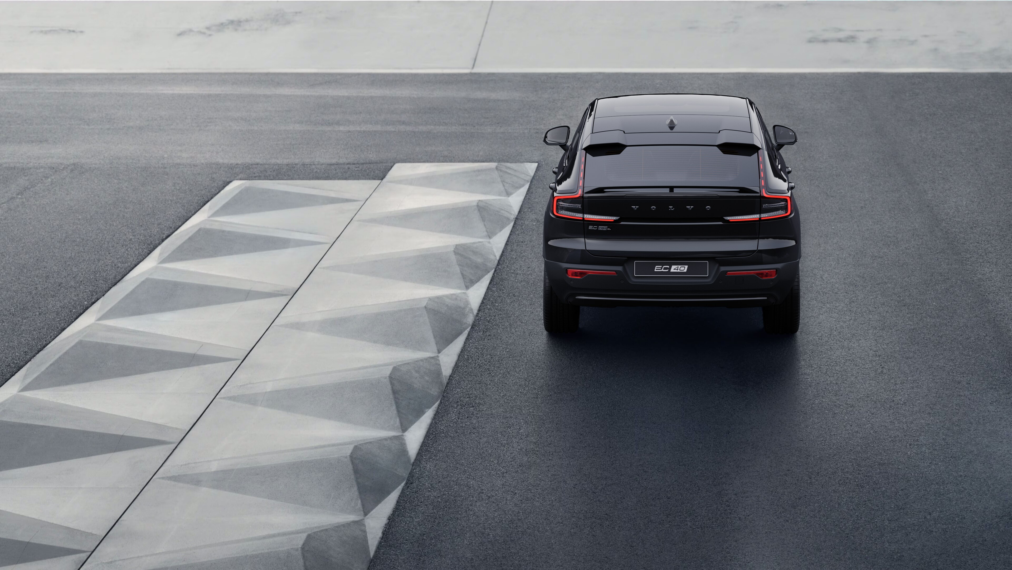 Sahilboyu arxa fona malik küləkli sahil yolunda Volvo avtomobilinin arxa görünüşü.