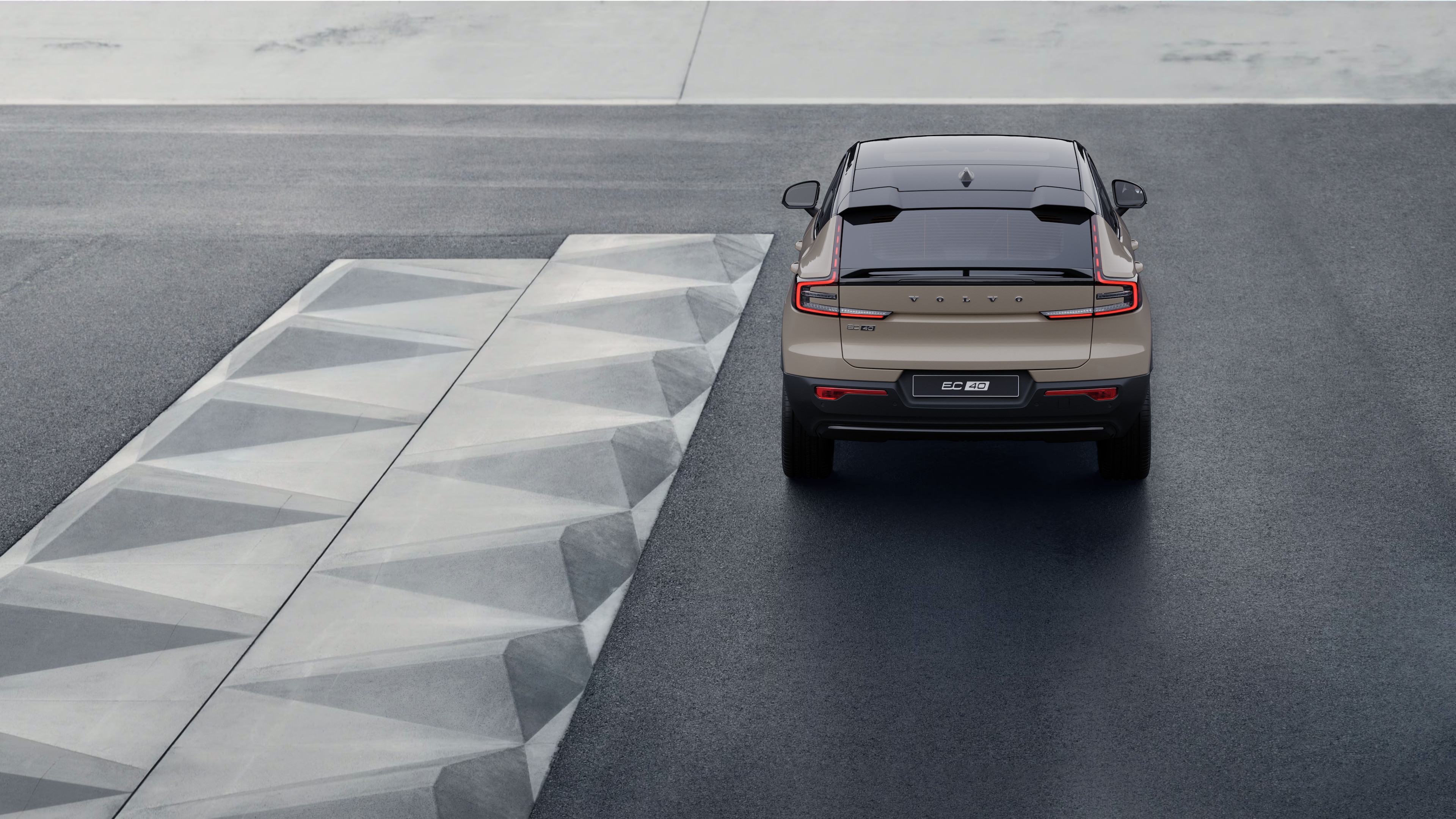 Vue arrière d’une Volvo sur une route côtière sinueuse avec un arrière-plan en bord de mer.