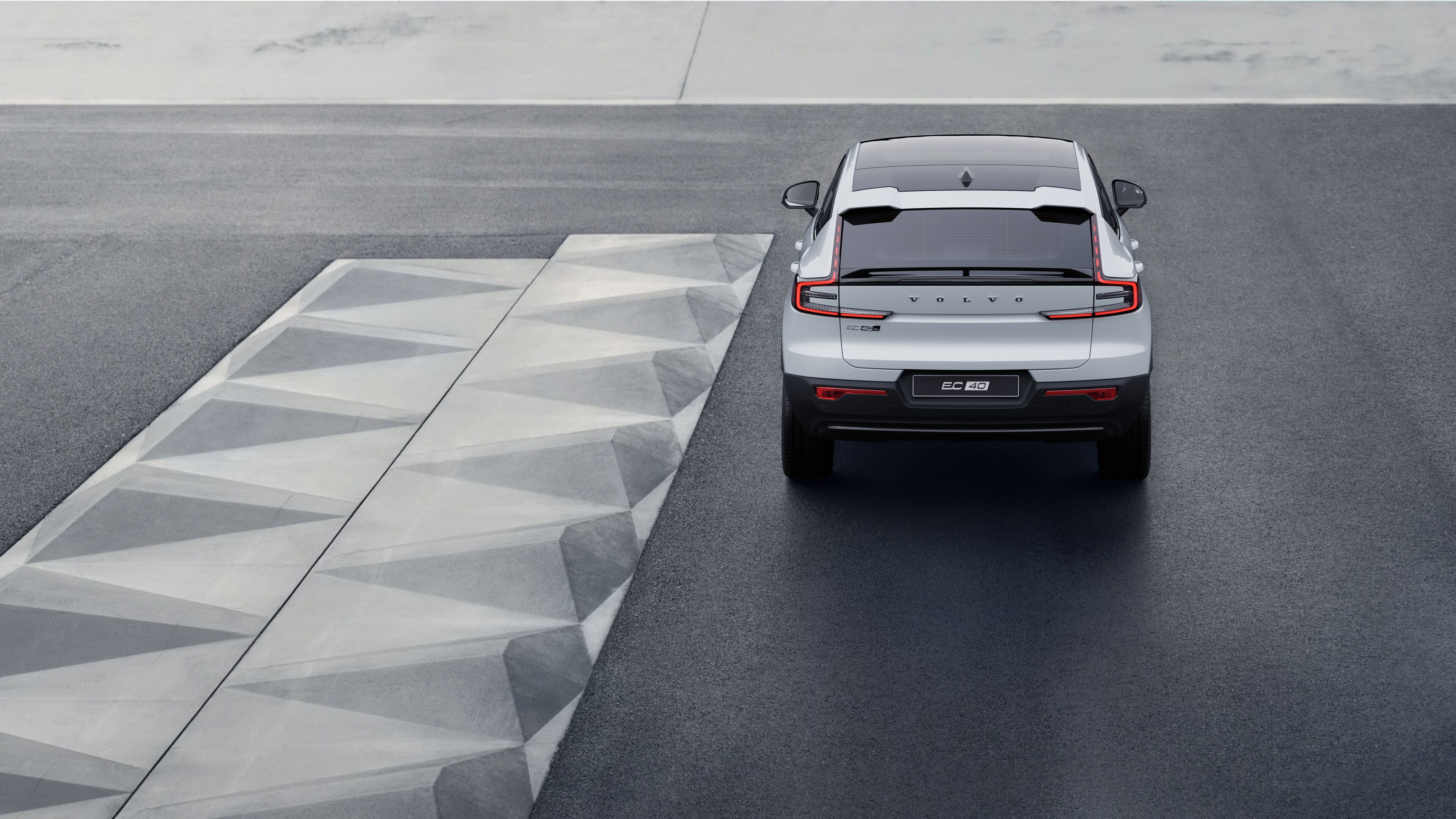 Sahilboyu arxa fona malik küləkli sahil yolunda Volvo avtomobilinin arxa görünüşü.