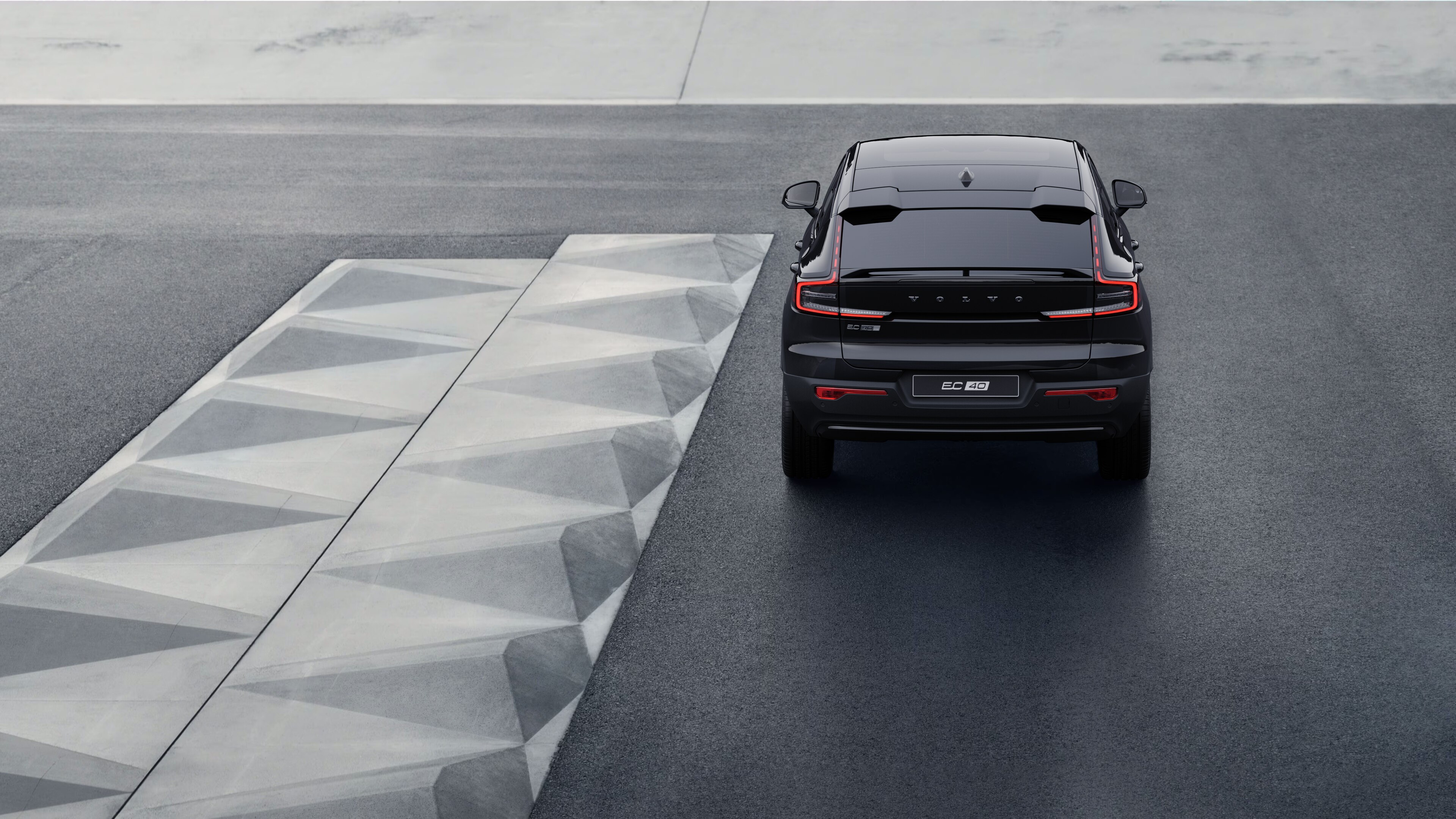 Vista trasera del vehículo Volvo en una sinuosa carretera costera con un fondo junto a la playa.
