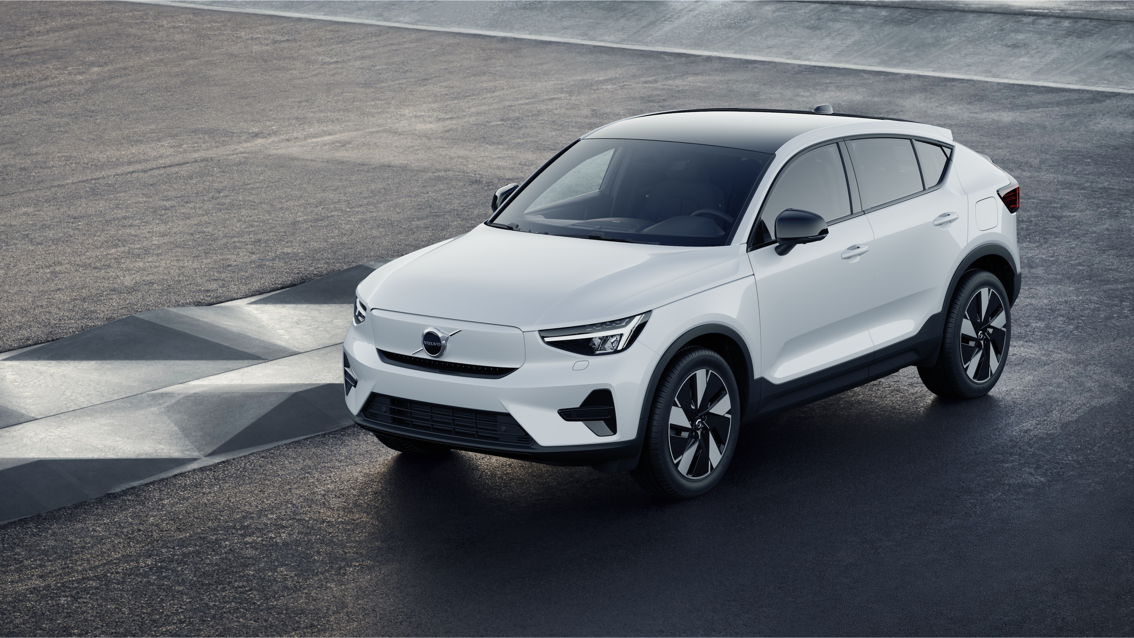 Volvobilens exteriör i trekvartsvy mot en industriell betongväggsbakgrund.