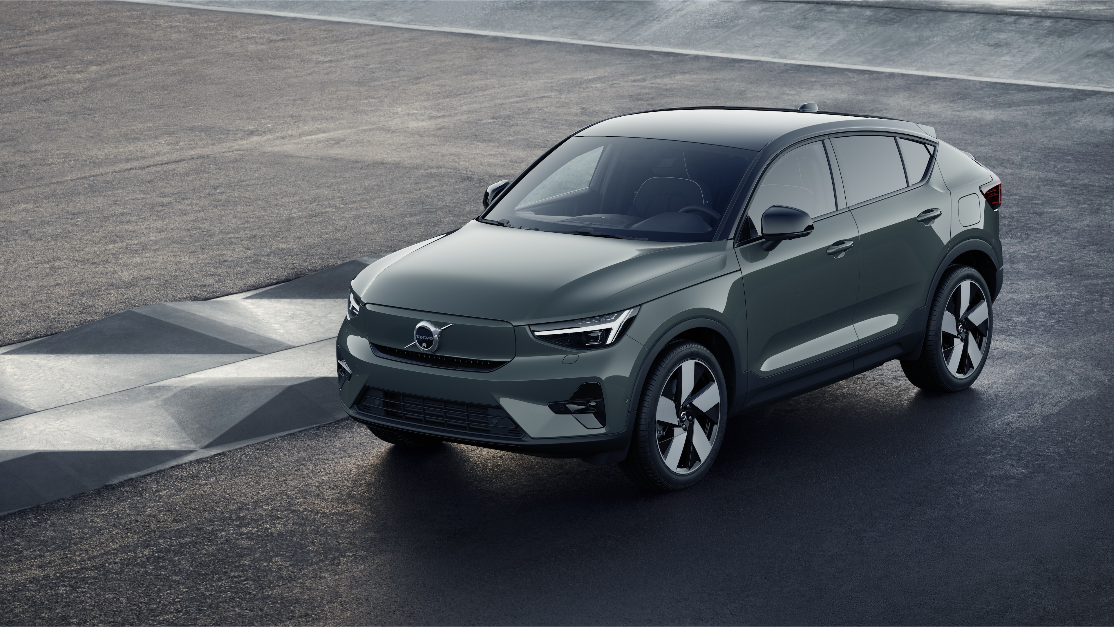 Extérieur d’une voiture Volvo en vue de trois quarts sur un fond de mur industriel en béton.