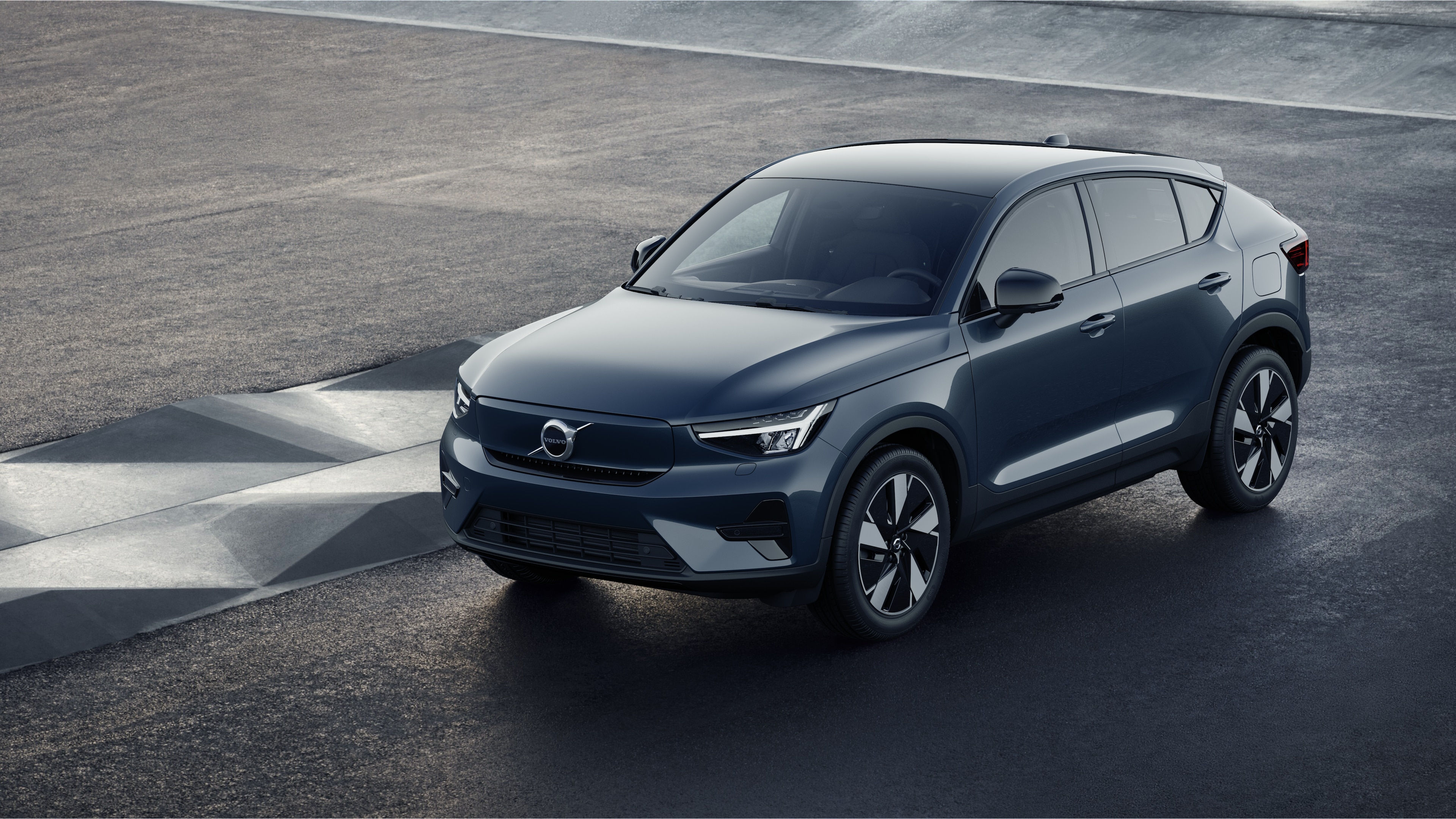 Volvo-bilens ydre i trekvartbillede mod en industriel betonvægbaggrund.