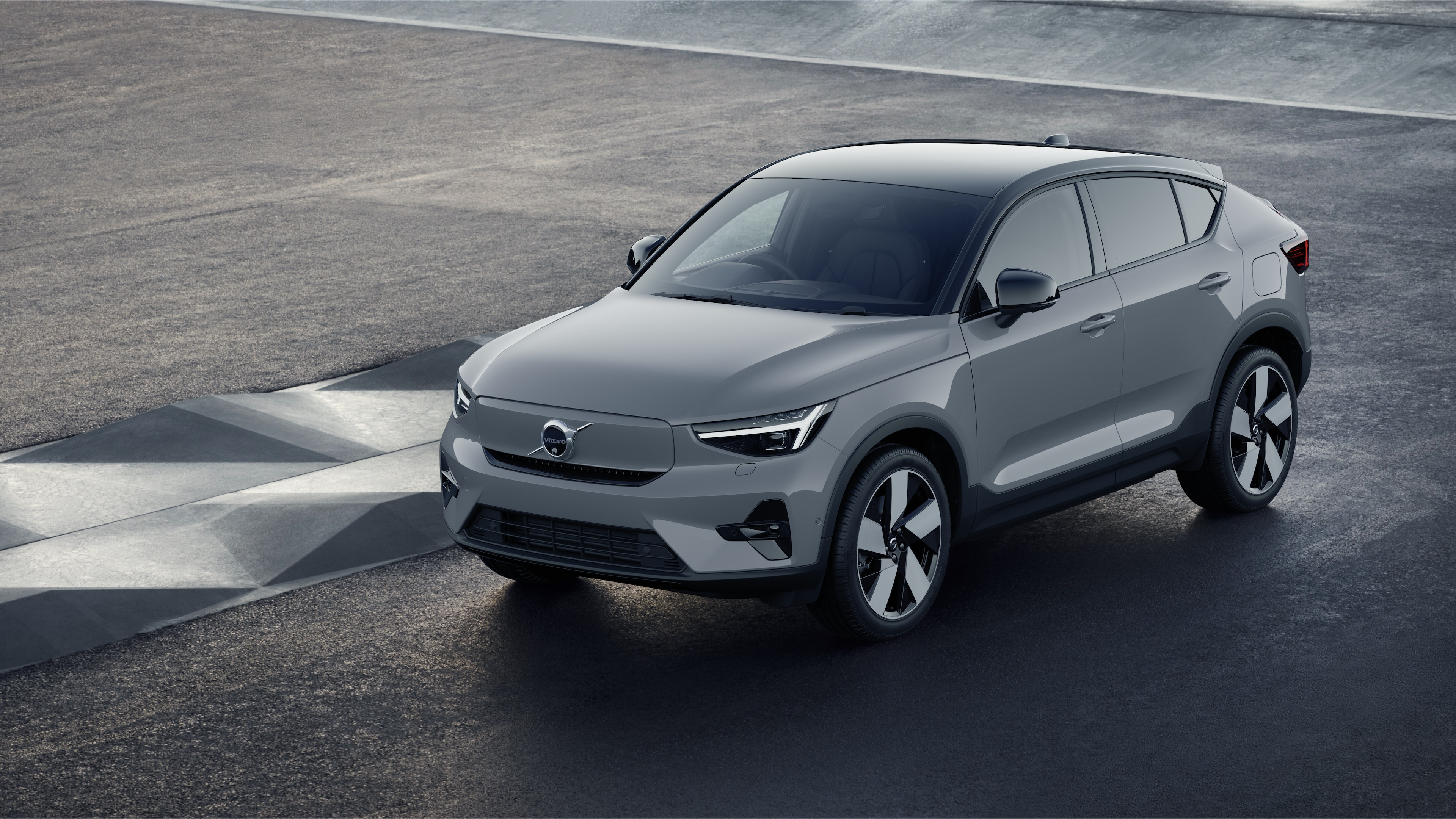 Volvo car exterior in three-quarter view against an industrial concrete wall background.