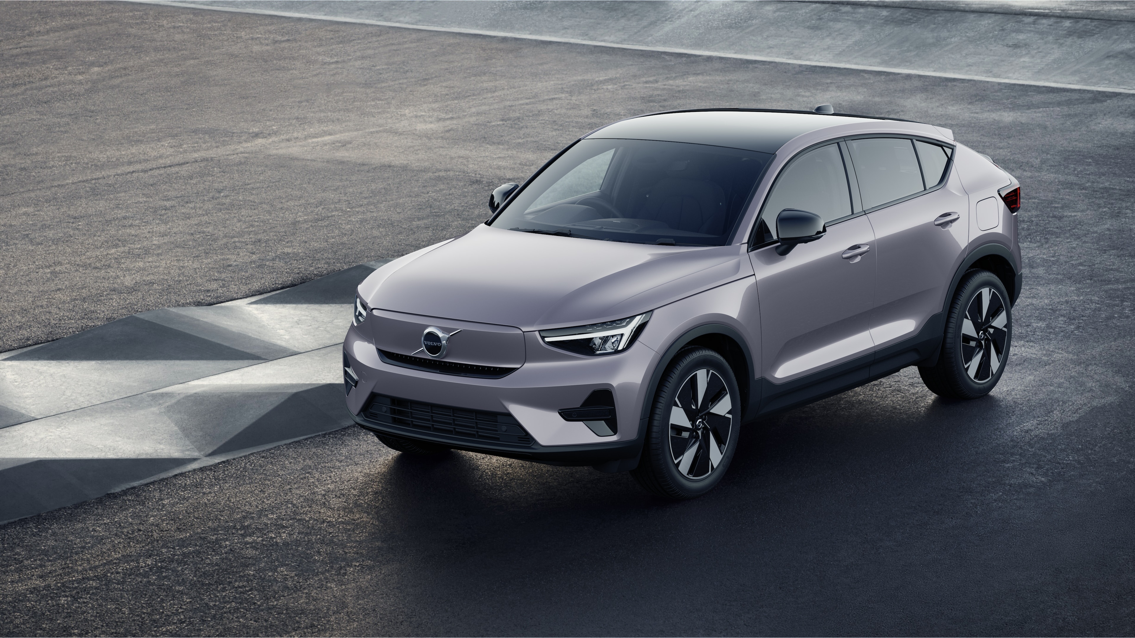 Volvo car exterior in three-quarter view against an industrial concrete wall background.