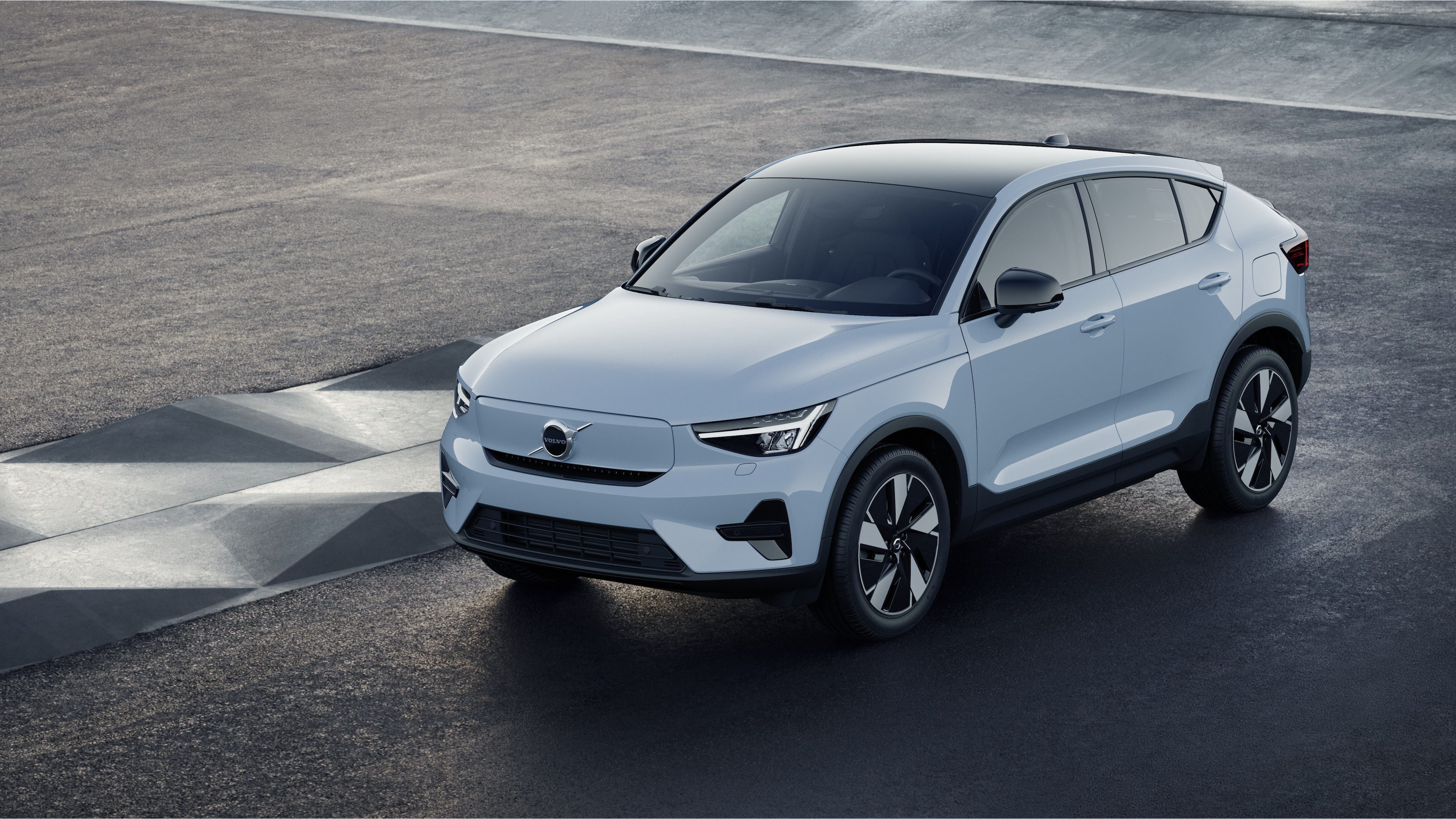 Volvo-bil utvendig i trekvart visning mot en industriell betongveggbakgrunn.