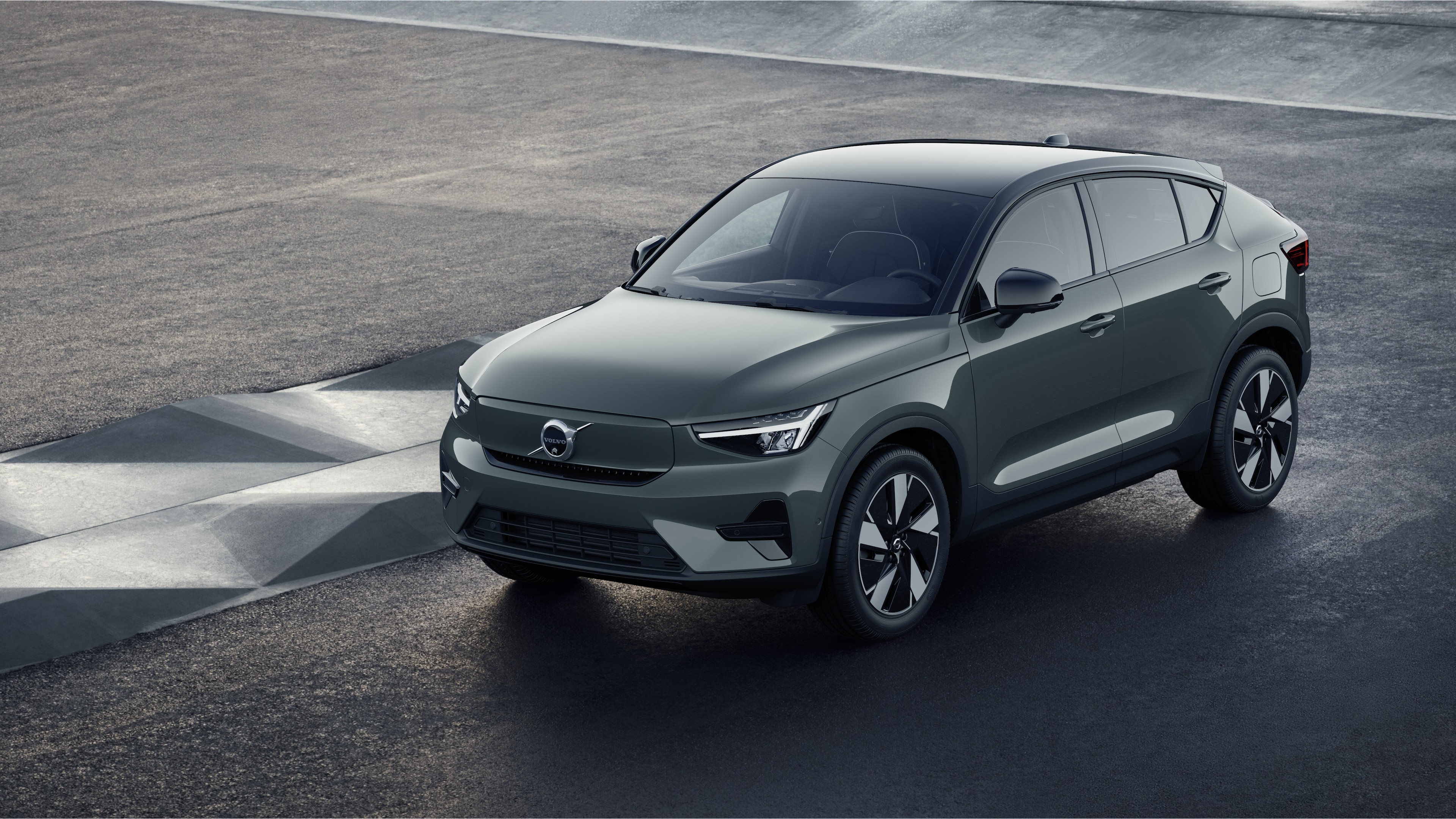 Endüstriyel beton duvar arka planında dörtte üç görünümde Volvo otomobilin dış görünümü.