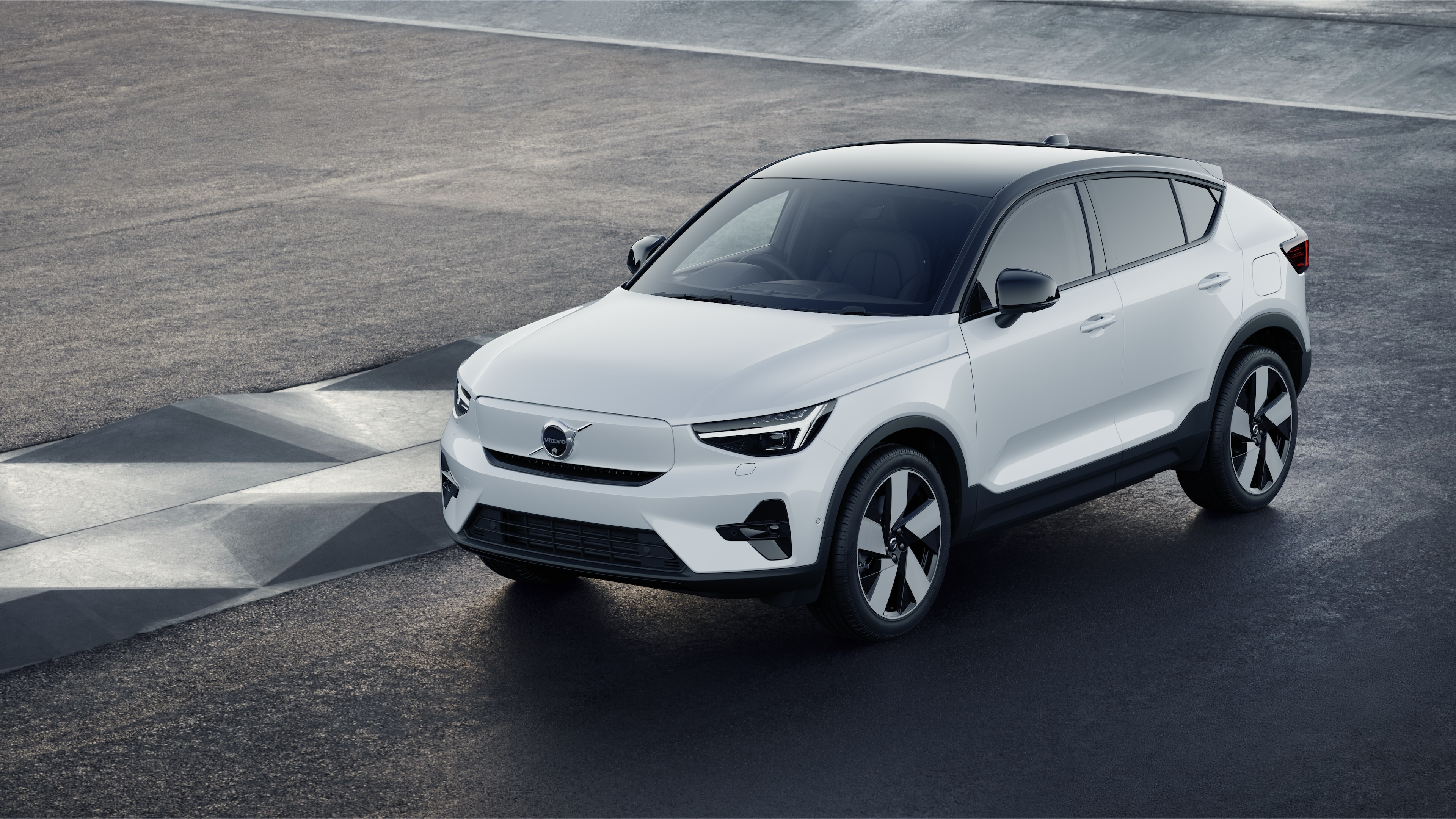 Volvo car exterior in three-quarter view against an industrial concrete wall background.
