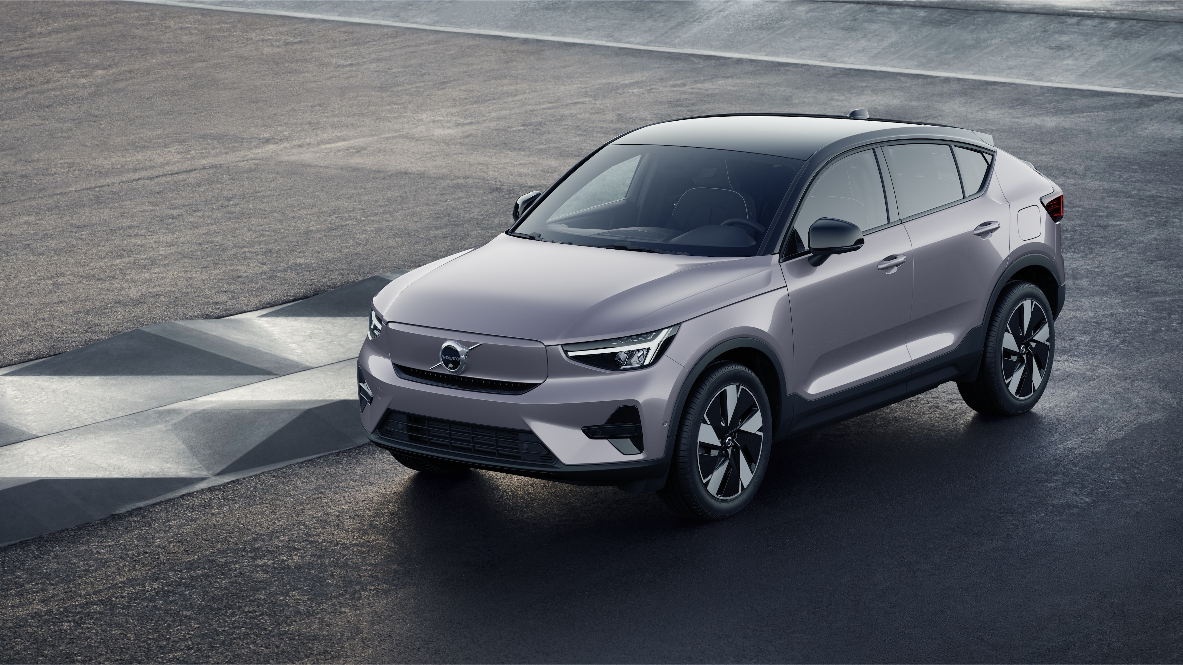 Endüstriyel beton duvar arka planında dörtte üç görünümde Volvo otomobilin dış görünümü.