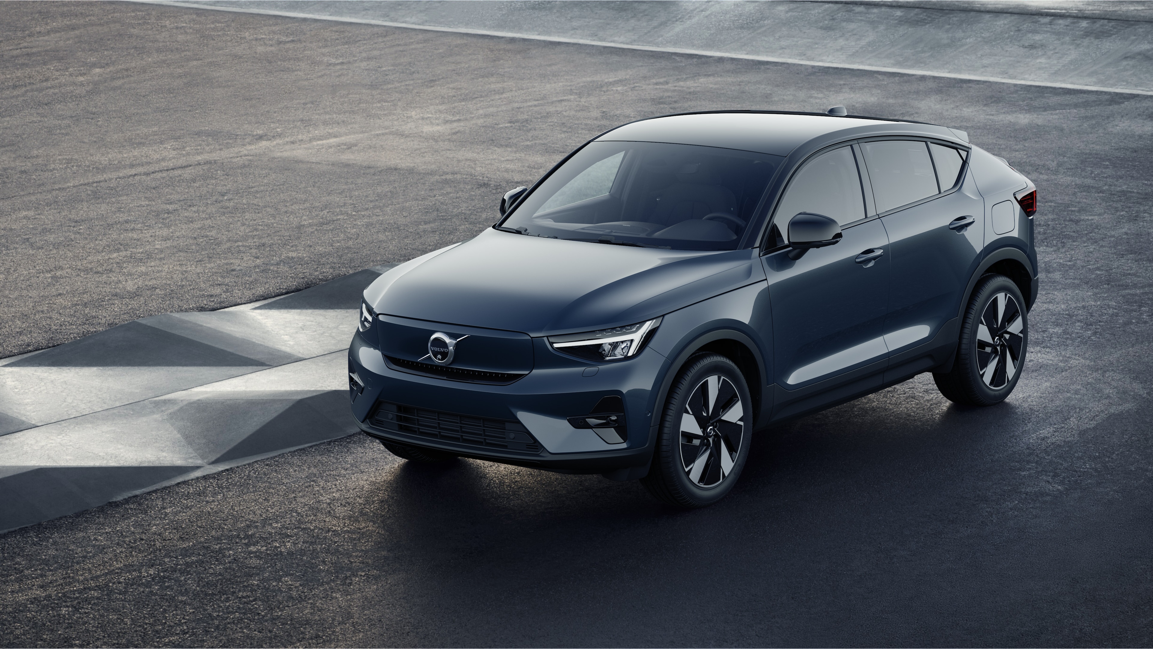 Volvo-bilens ydre i trekvartbillede mod en industriel betonvægbaggrund.