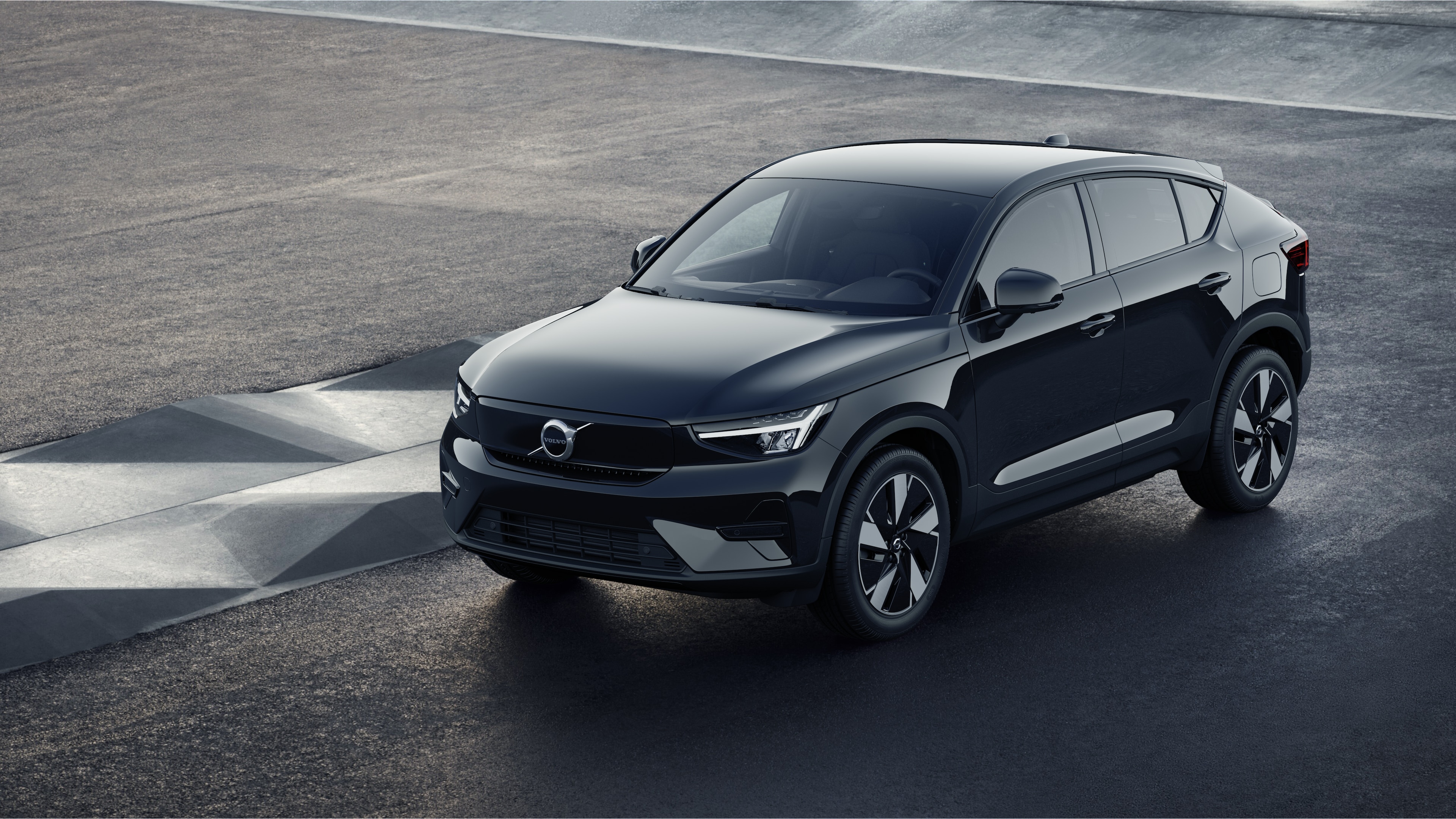 Volvo მანქანის ექსტერიერი სამი მეოთხედი ხედით სამრეწველო ბეტონის კედლის ფონზე.