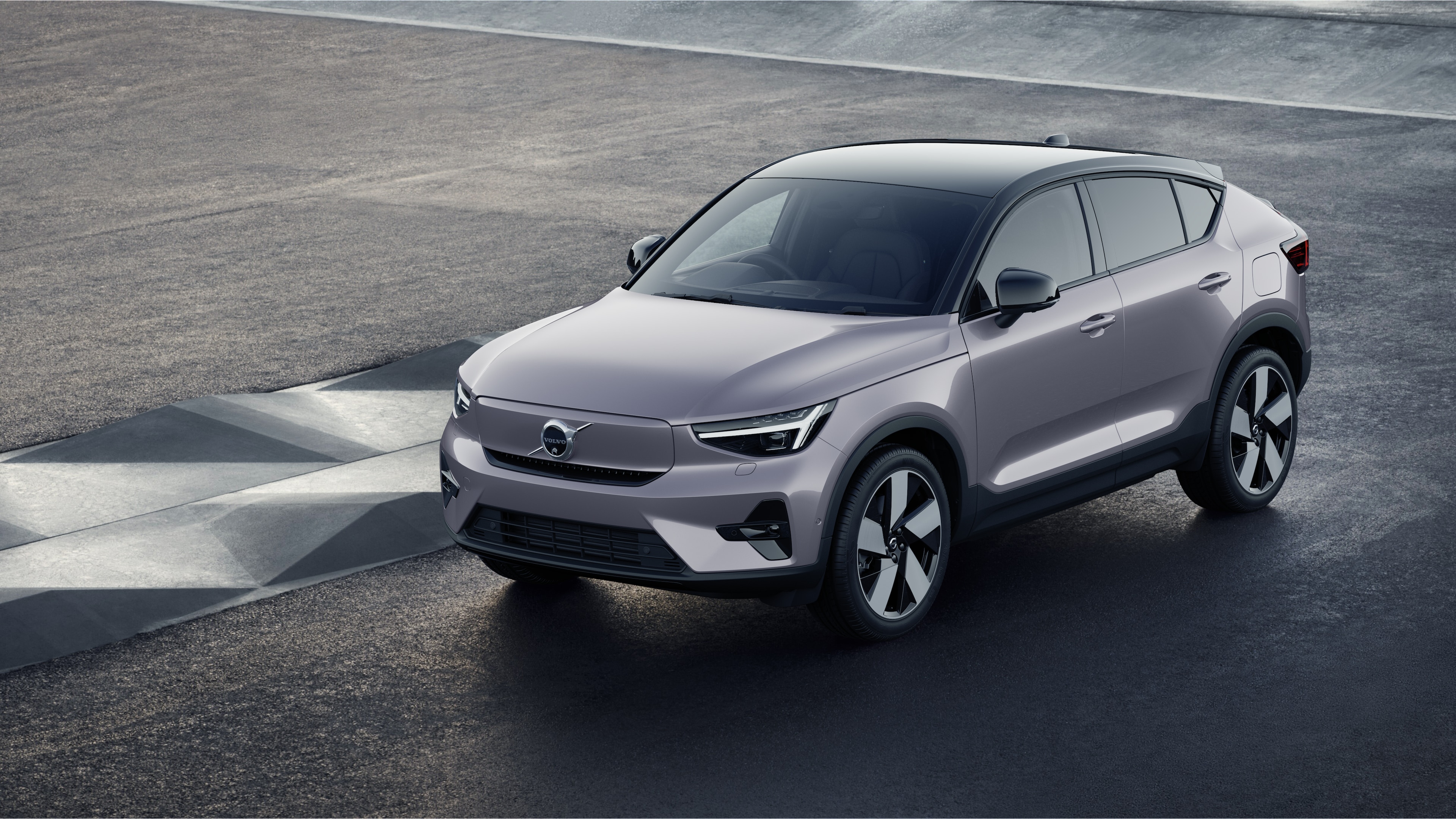 Volvo car exterior in three-quarter view against an industrial concrete wall background.