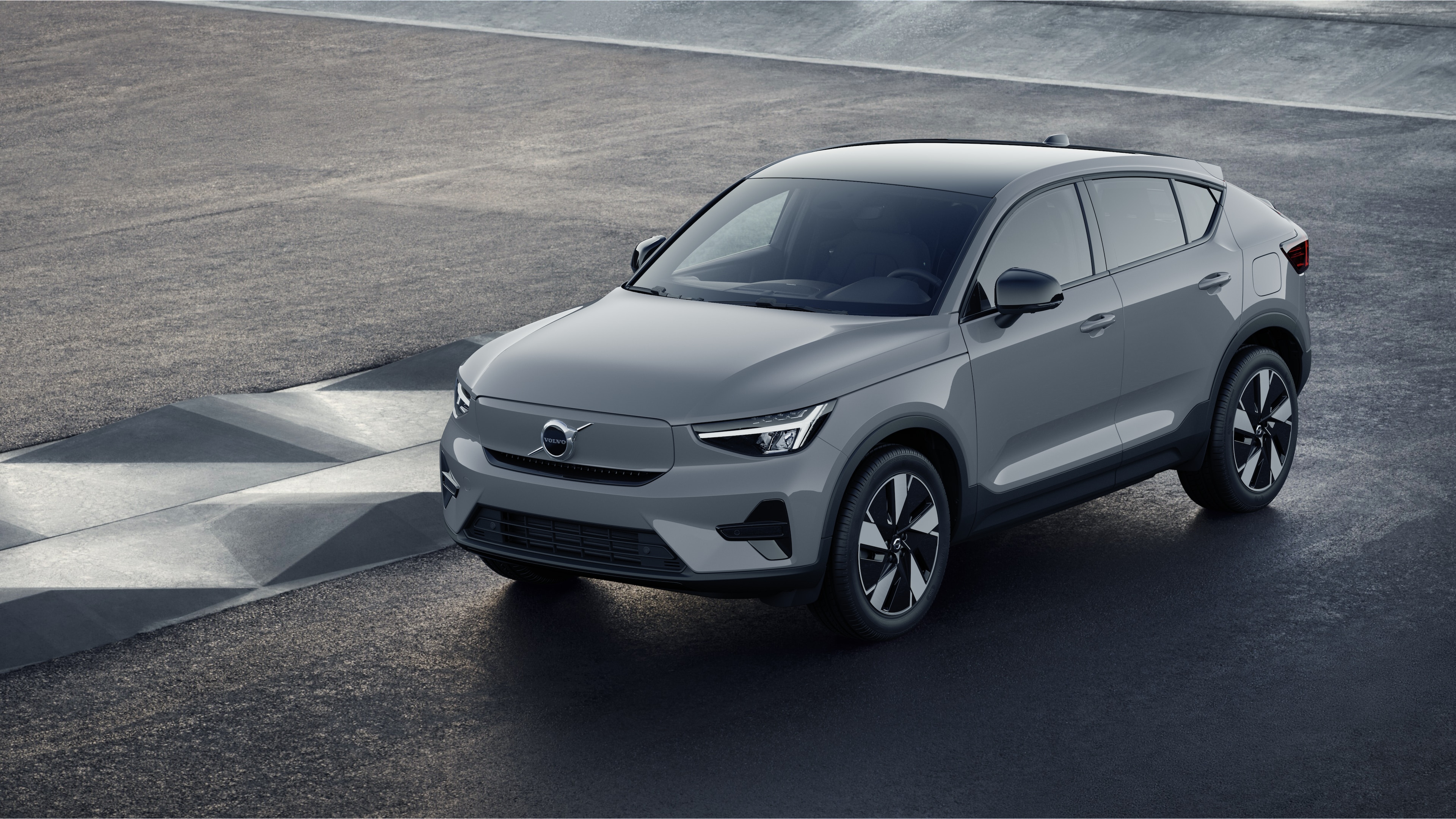 Exterieur van een Volvo in driekwart aanzicht tegen een achtergrond van een industriële betonnen muur.