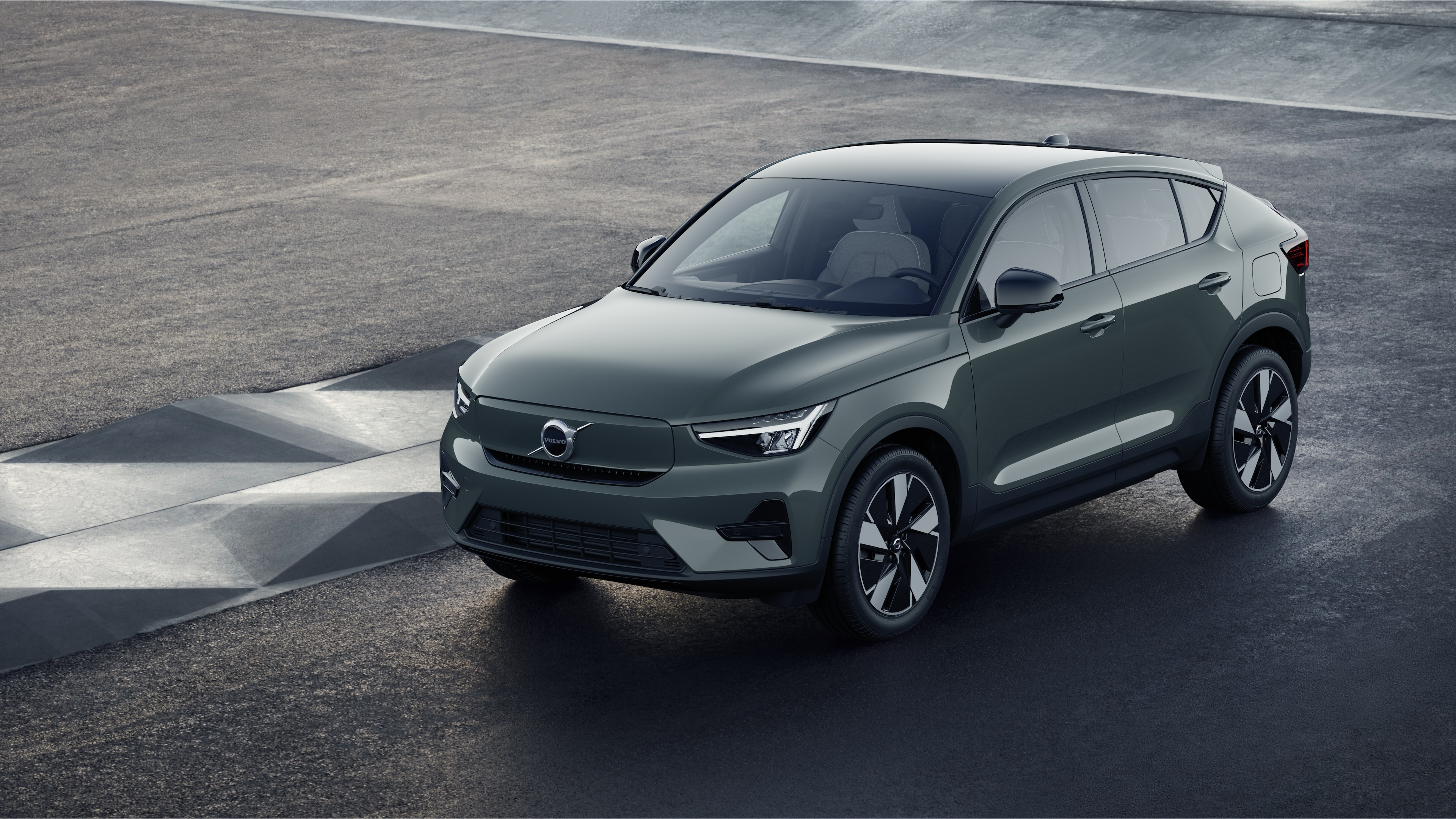 Exterior do carro Volvo em vista de três quartos contra um fundo de parede de concreto industrial.