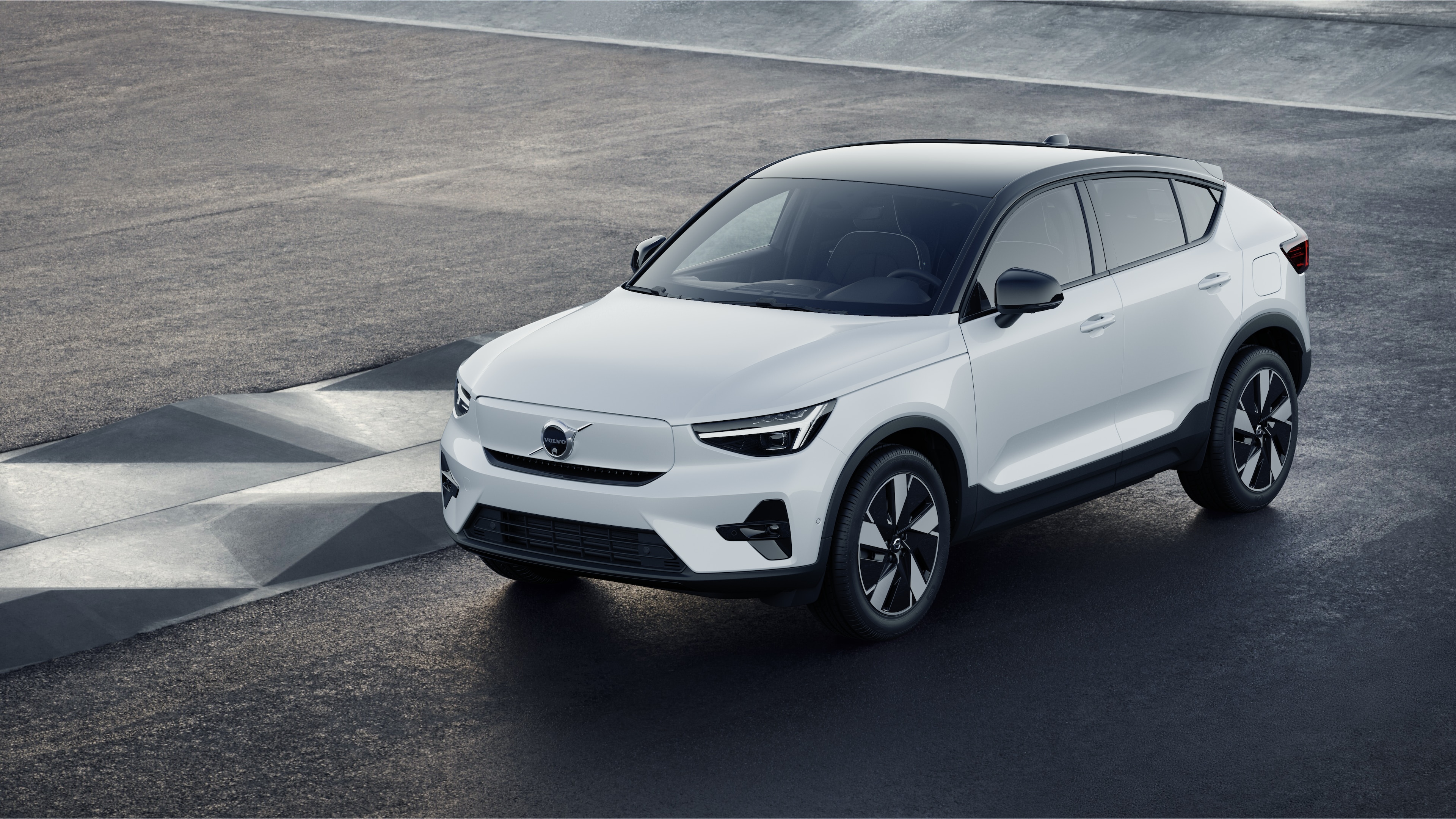 Volvo car exterior in three-quarter view against an industrial concrete wall background.