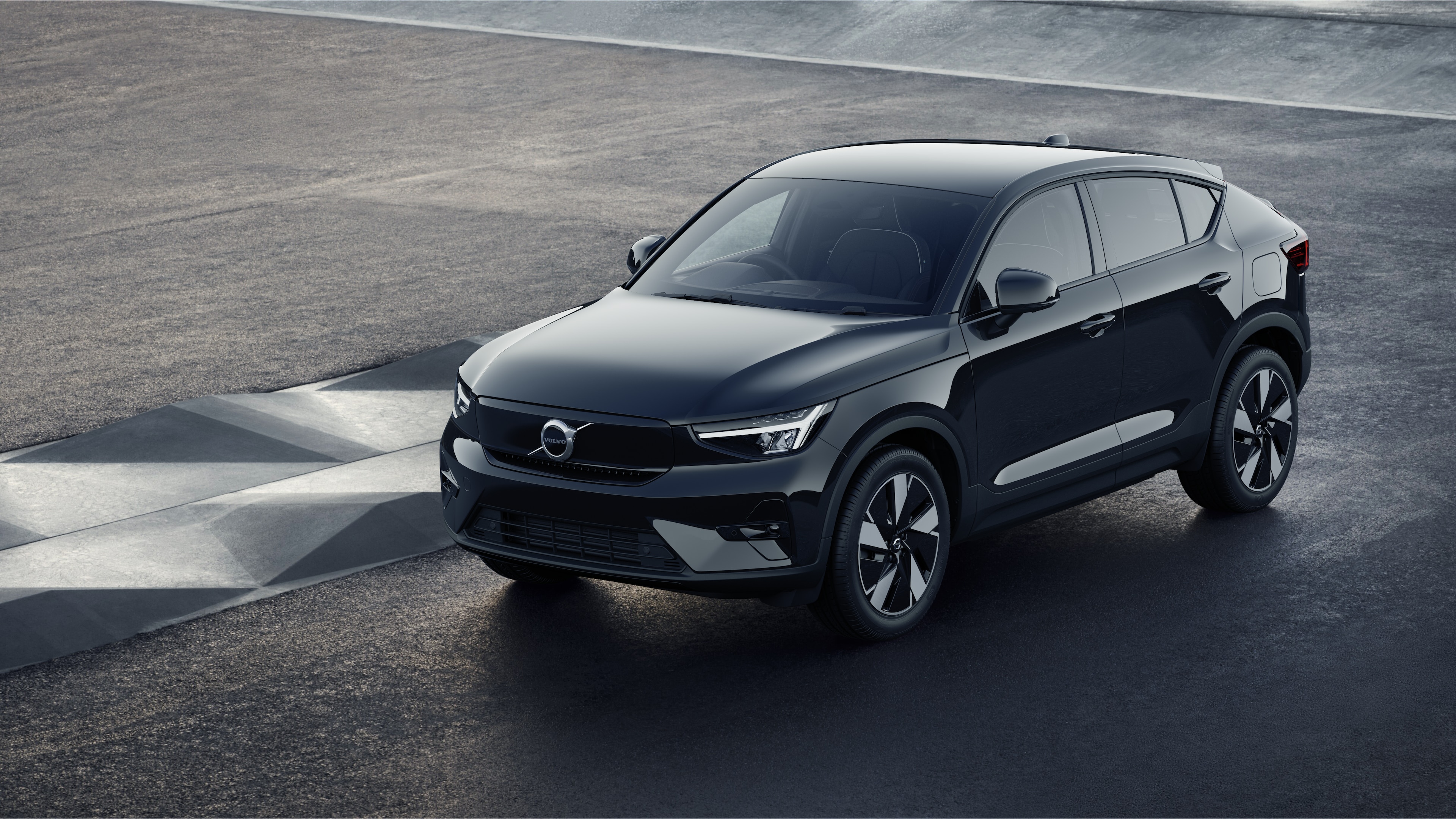 Volvo car exterior in three-quarter view against an industrial concrete wall background.
