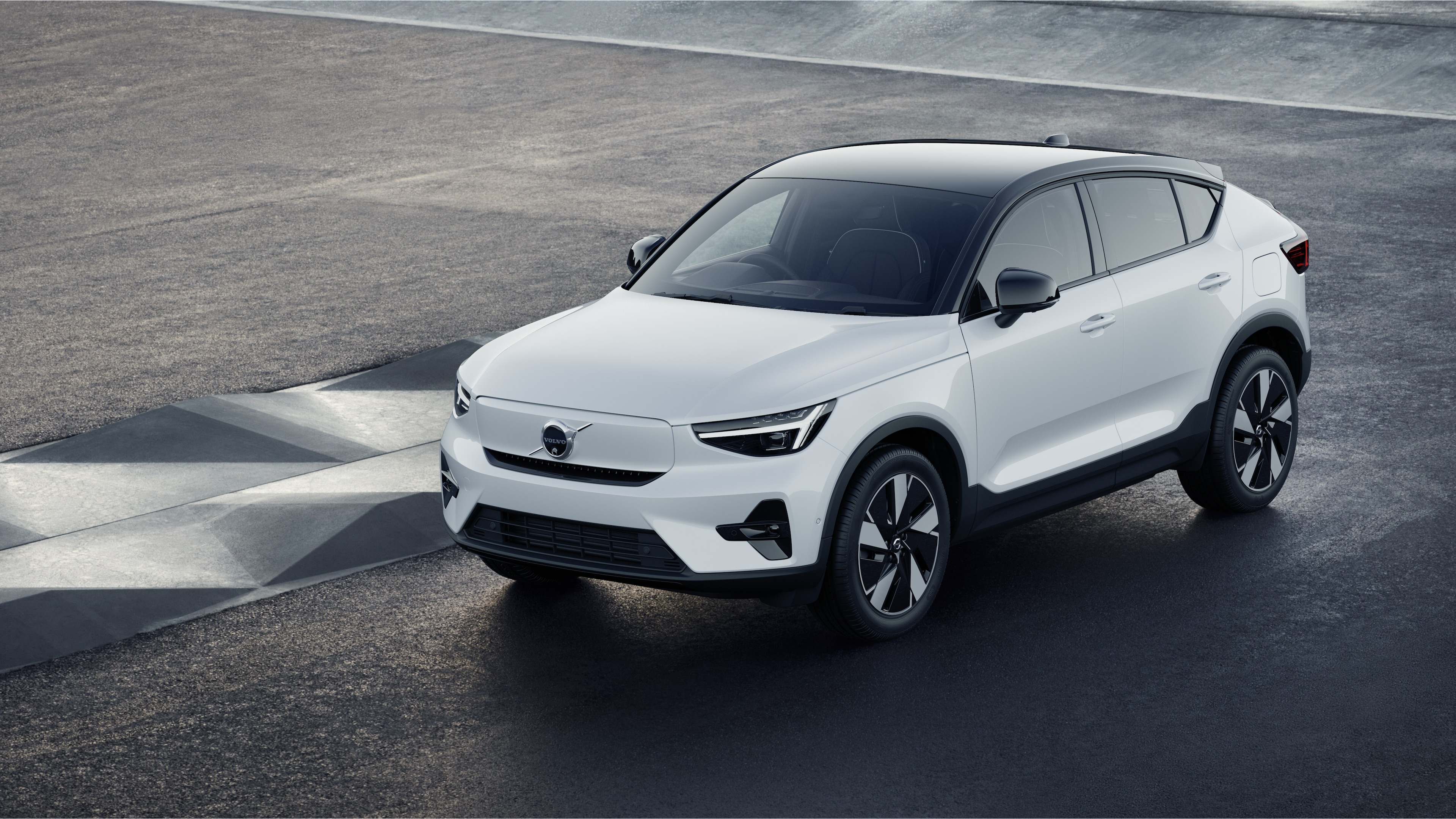 Volvo car exterior in three-quarter view against an industrial concrete wall background.