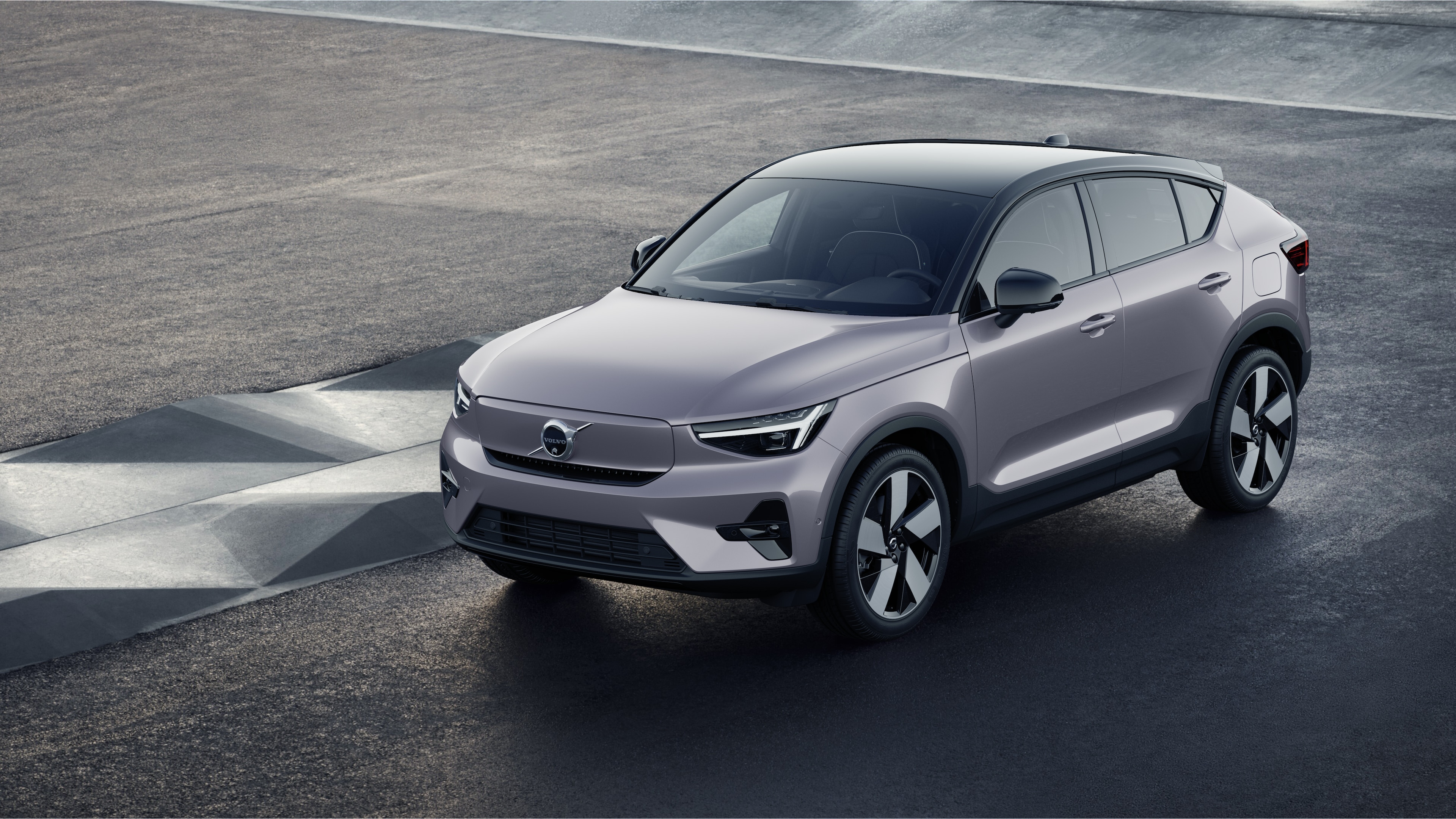 Exterior del vehículo Volvo en vista de tres cuartos sobre un fondo de muro de hormigón industrial.