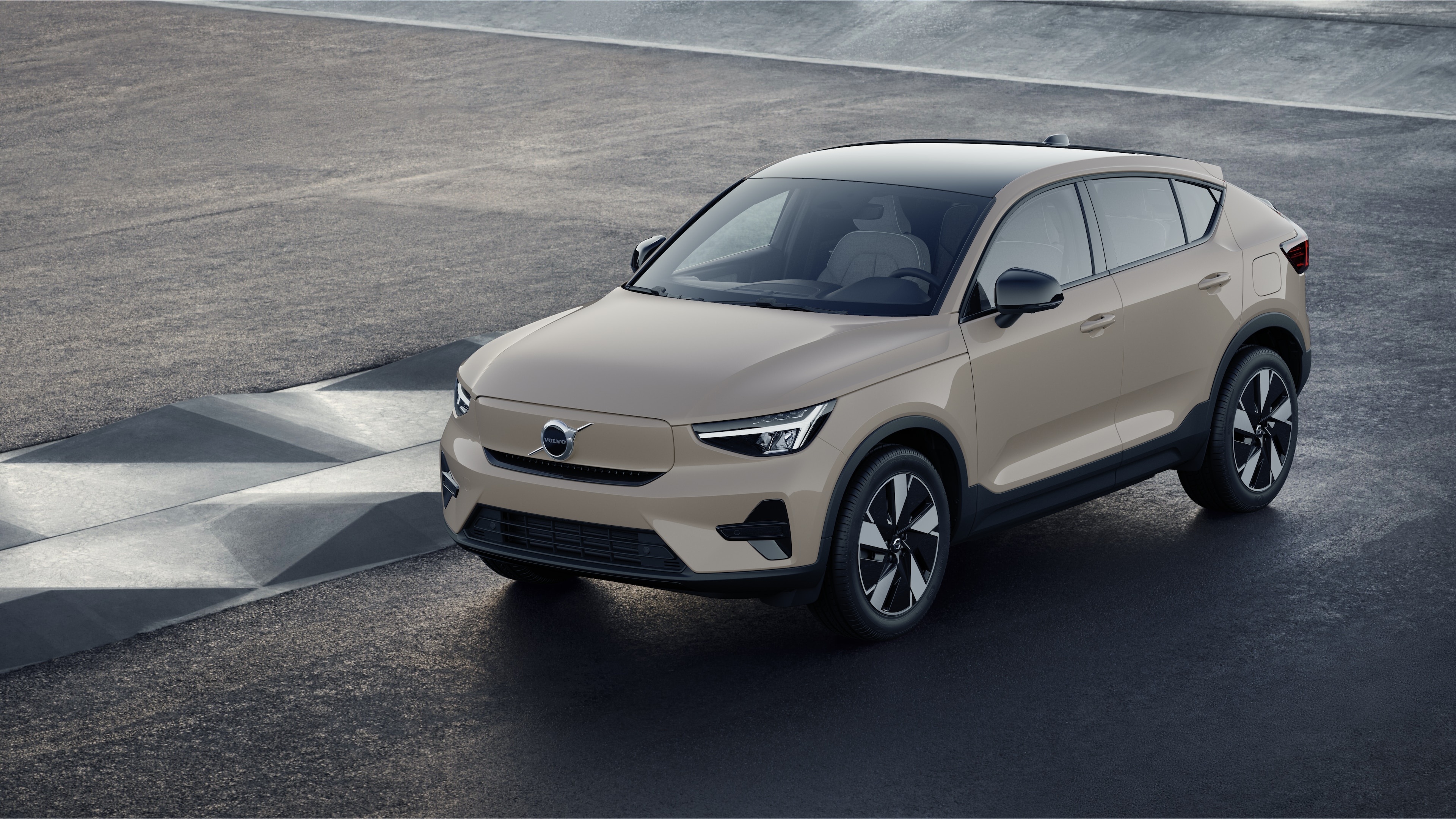 Exterior do carro Volvo em vista de três quartos contra um fundo de parede de concreto industrial.