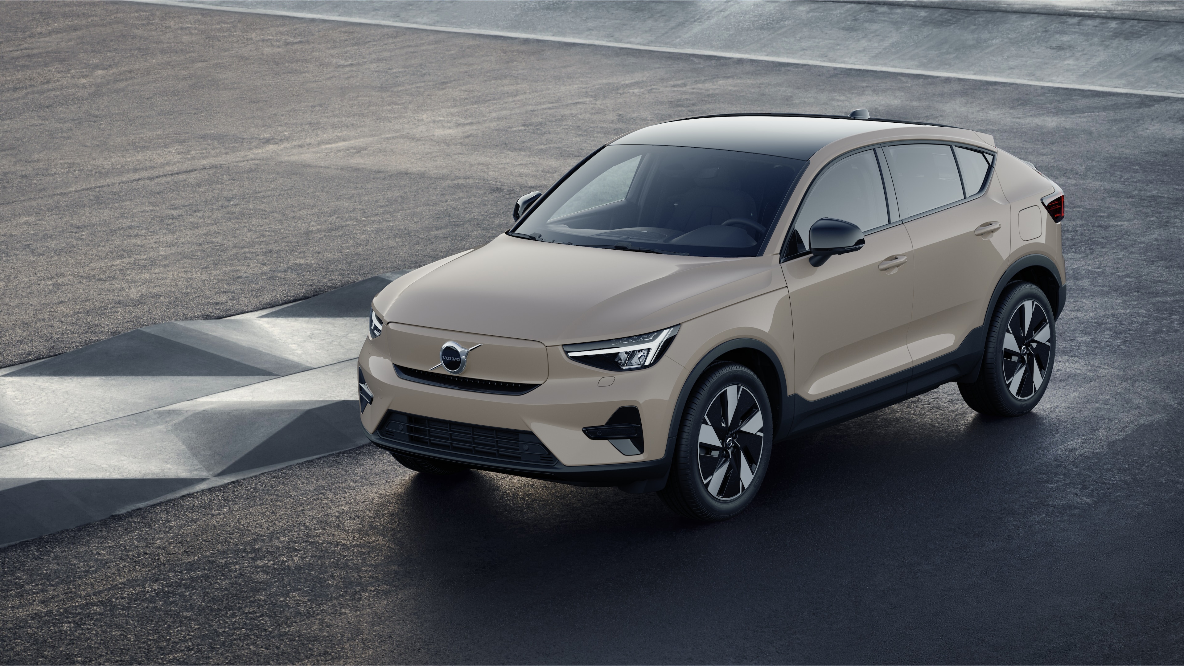 Volvobilens exteriör i trekvartsvy mot en industriell betongväggsbakgrund.
