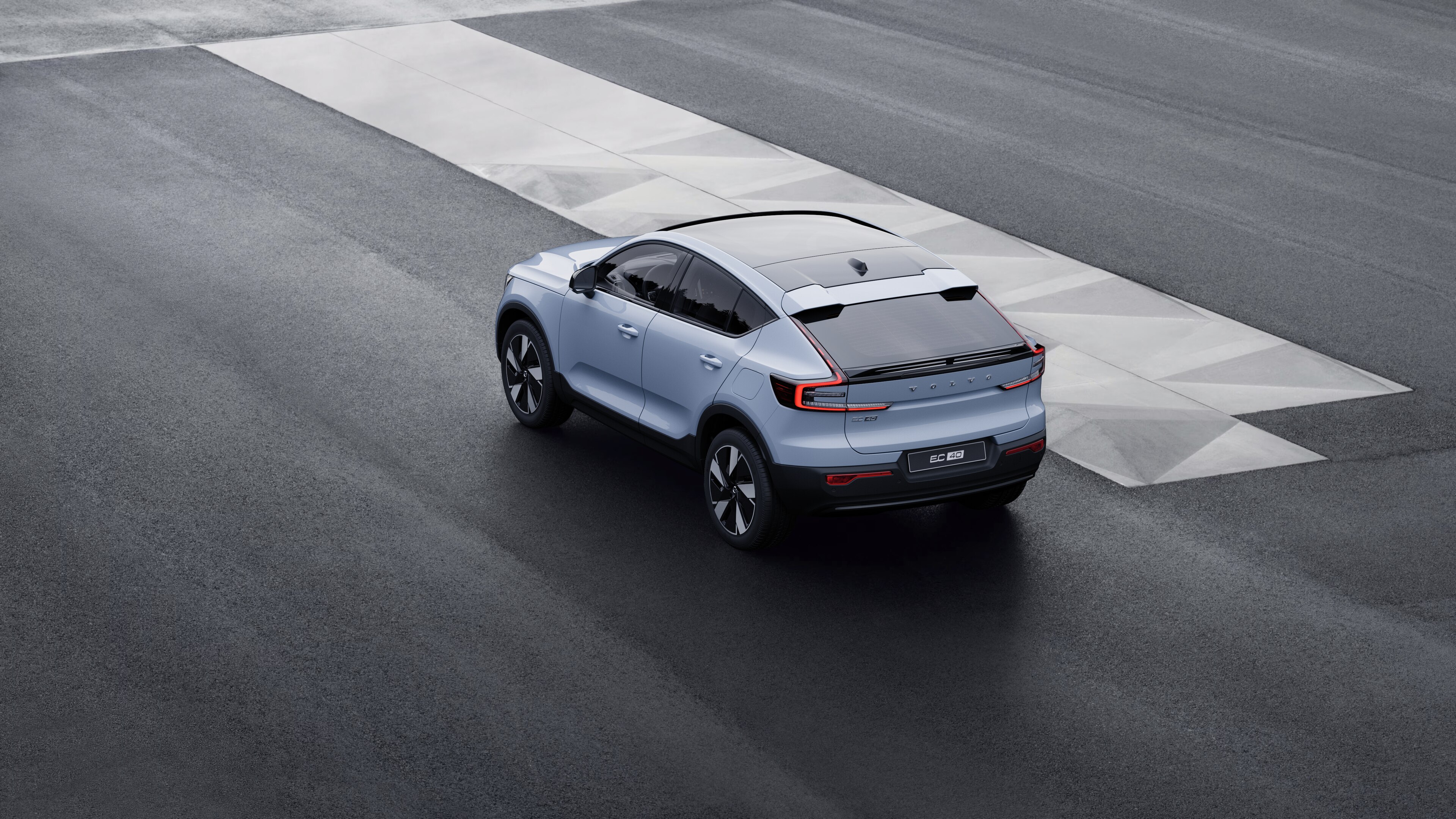 Αυτοκίνητο Volvo σε πίσω όψη τριών τετάρτων, σταθμευμένο σε τσιμεντένιο τοίχο σε αστικό φόντο.