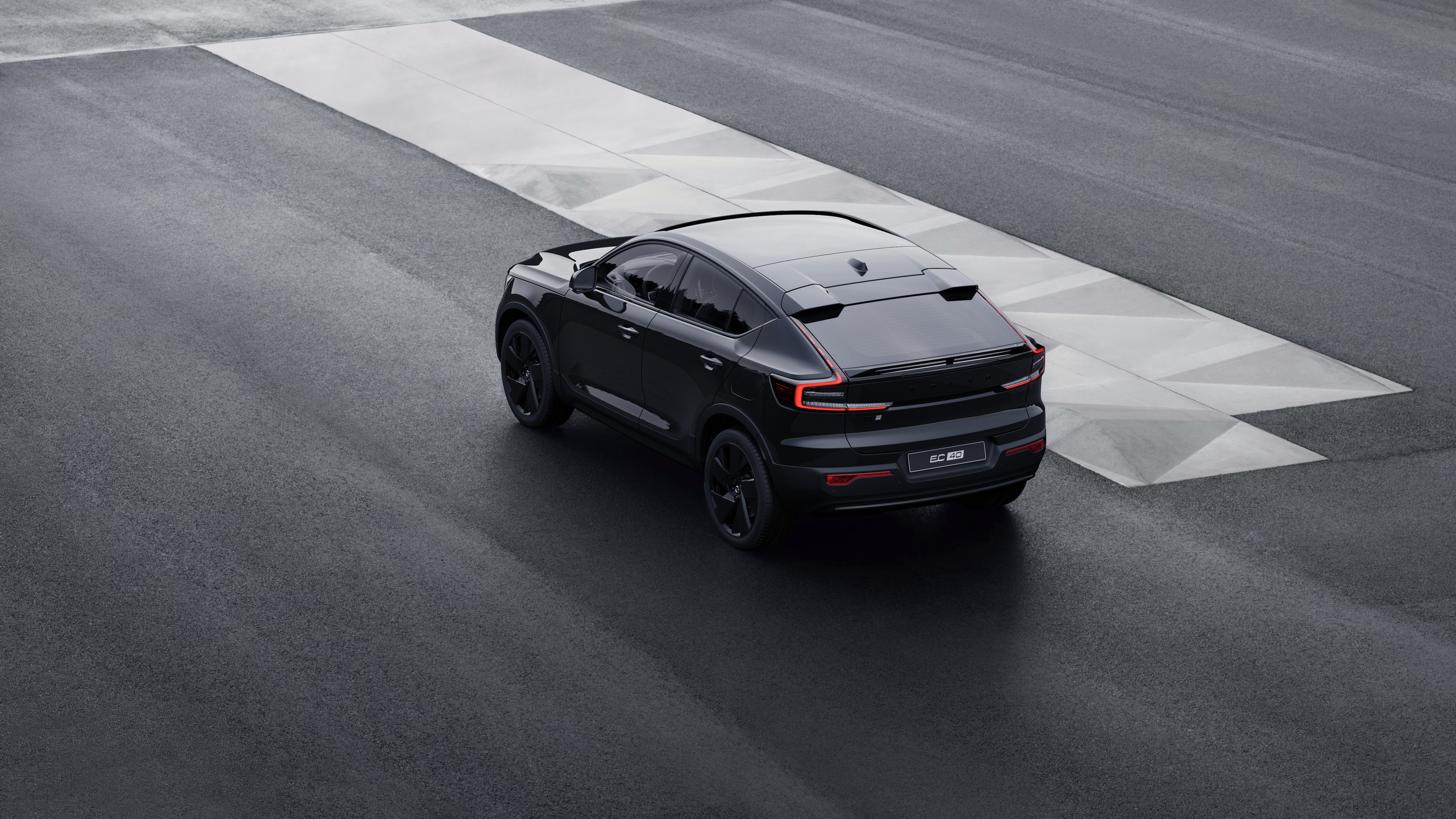 Dreiviertelansicht eines Volvo im hinteren Bereich, der vor einer Betonwand vor einem städtischen Straßenhintergrund geparkt ist.