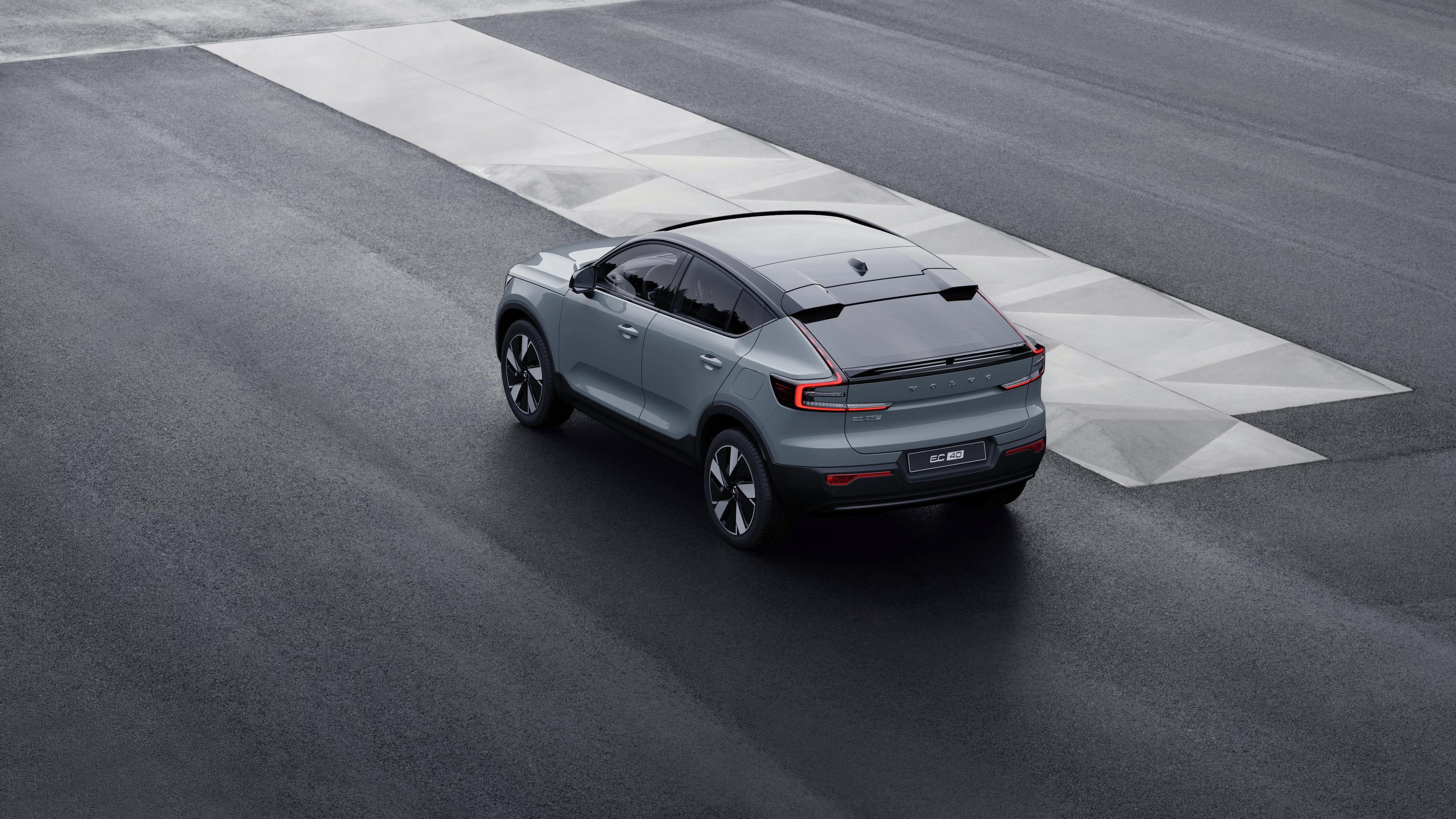 Volvo-auto takanäkymässä kolmen vartin näkymässä pysäköitynä betoniseinää vasten urbaanilla katutaustalla.