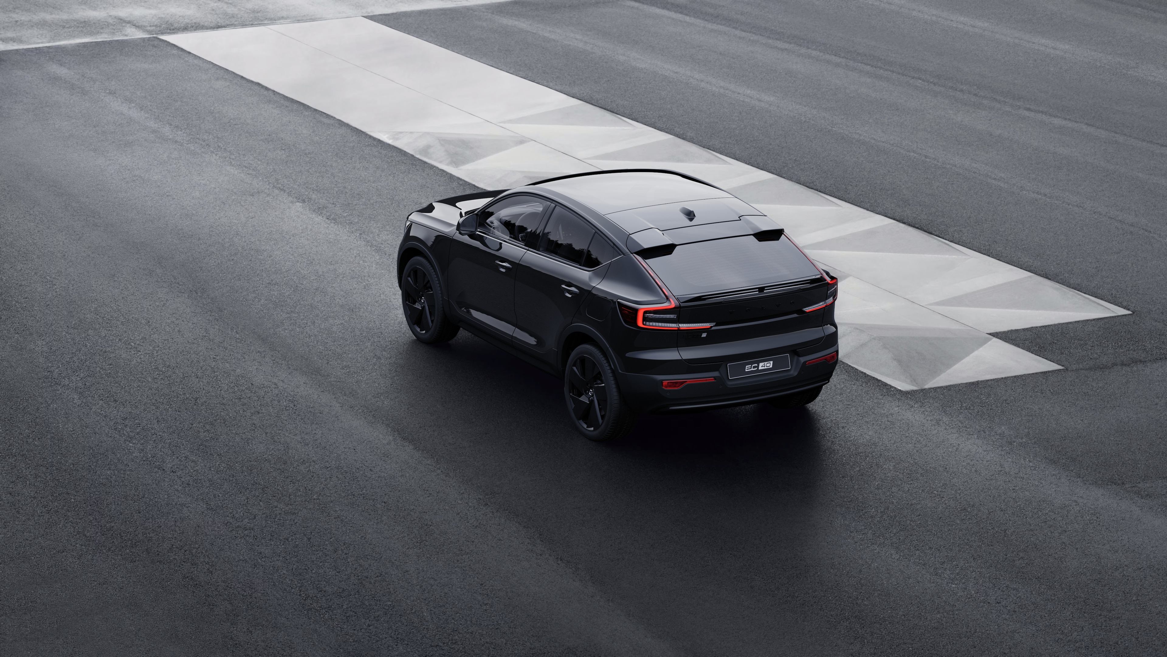 Volvo-auto takanäkymässä kolmen vartin näkymässä pysäköitynä betoniseinää vasten urbaanilla katutaustalla.