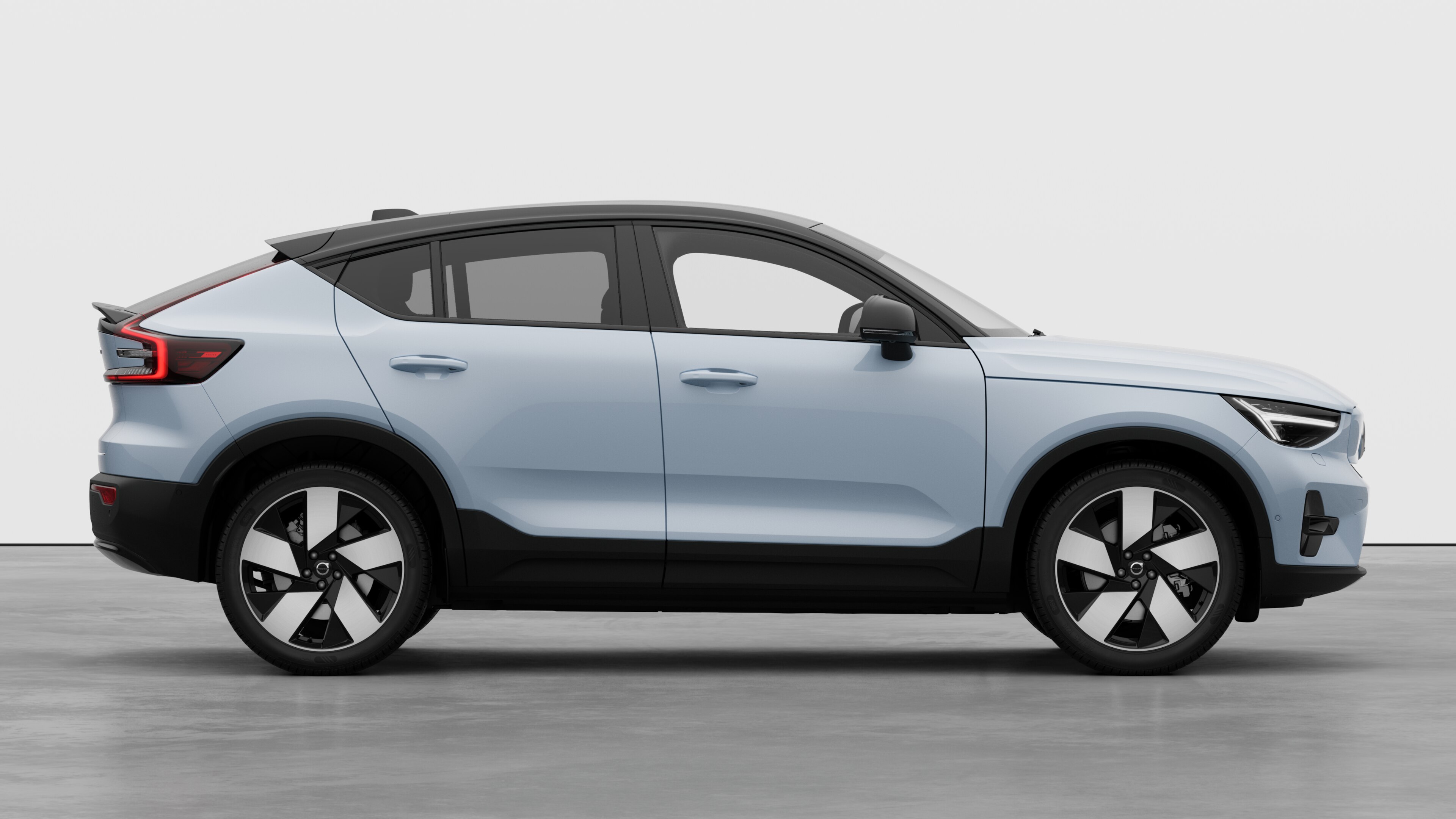 Volvo car side view on plain studio background displaying closed doors and visible wheel design.