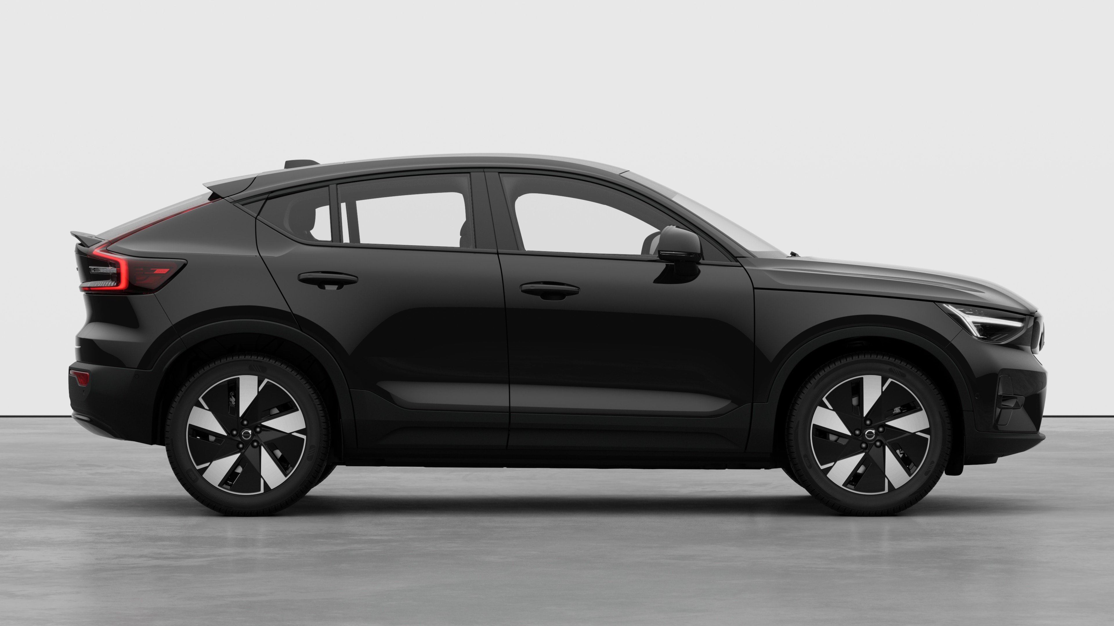 Volvo car side view on plain studio background displaying closed doors and visible wheel design.