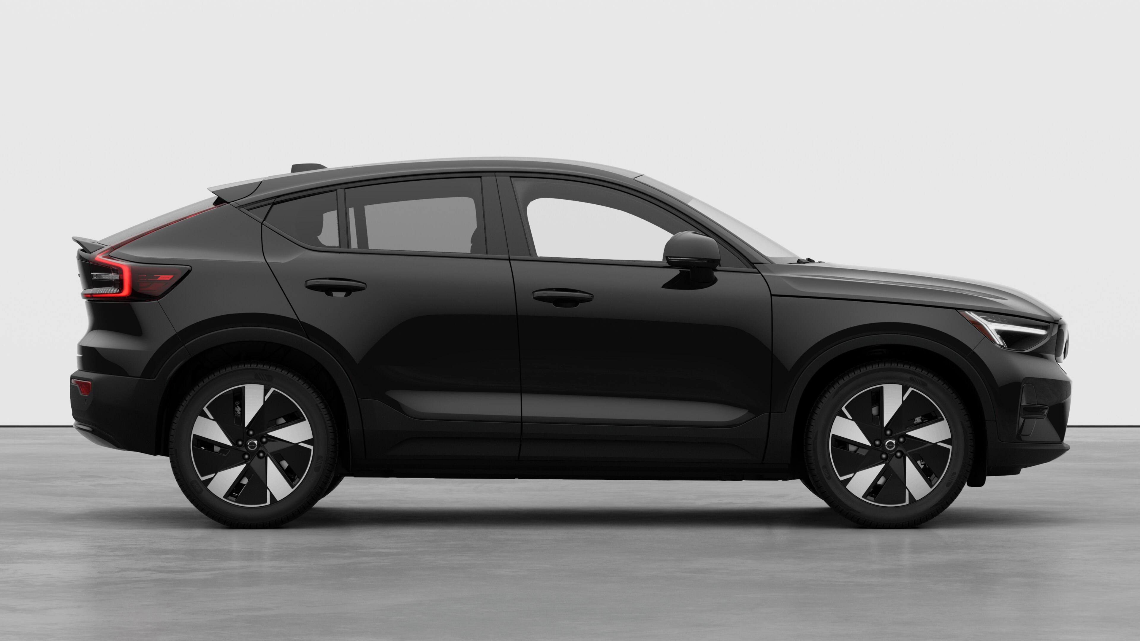 Vista lateral del vehículo Volvo sobre fondo de estudio liso que muestra las puertas cerradas y el diseño visible de las ruedas.