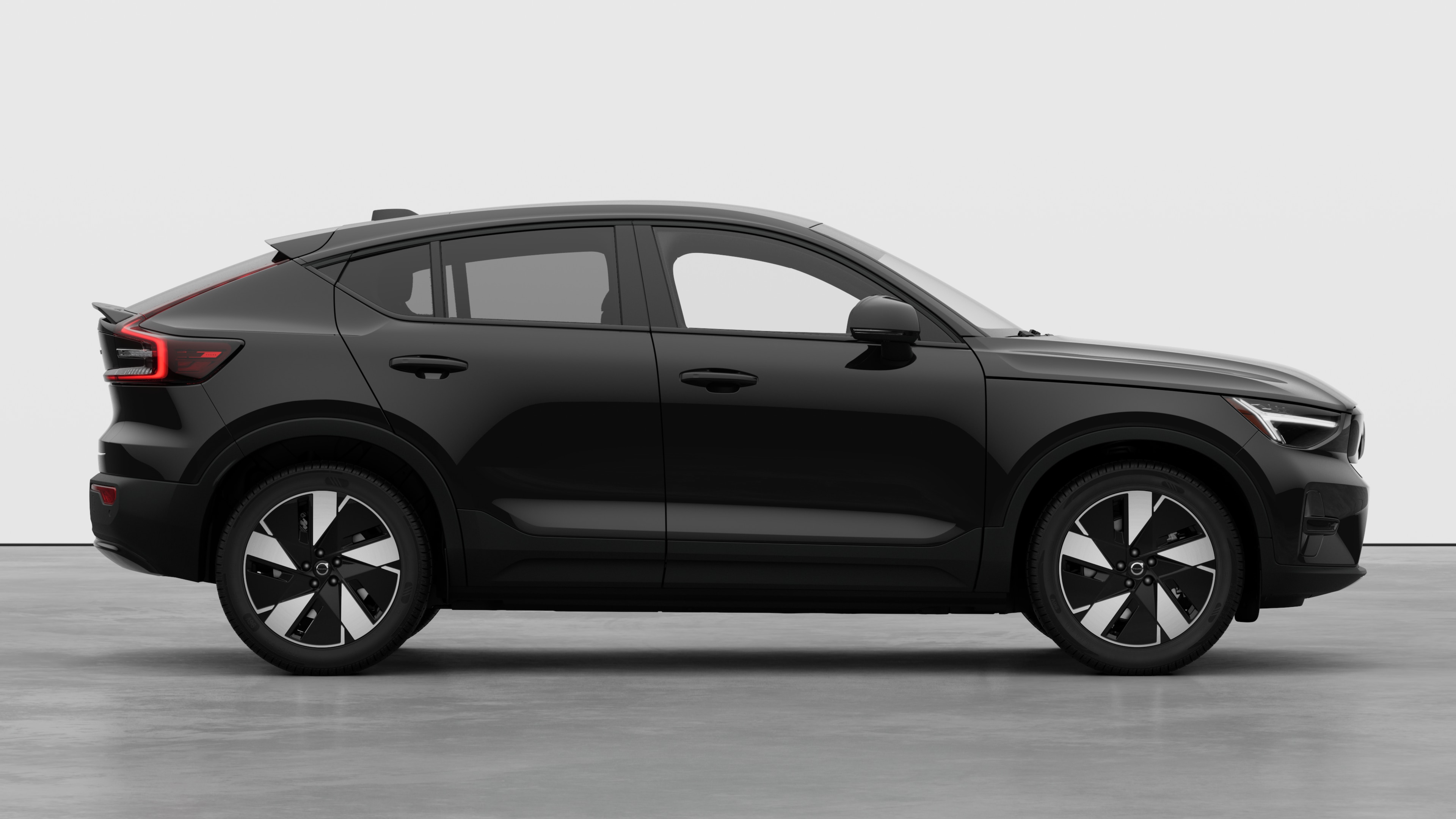 Vista lateral del vehículo Volvo sobre fondo de estudio liso que muestra las puertas cerradas y el diseño visible de las ruedas.