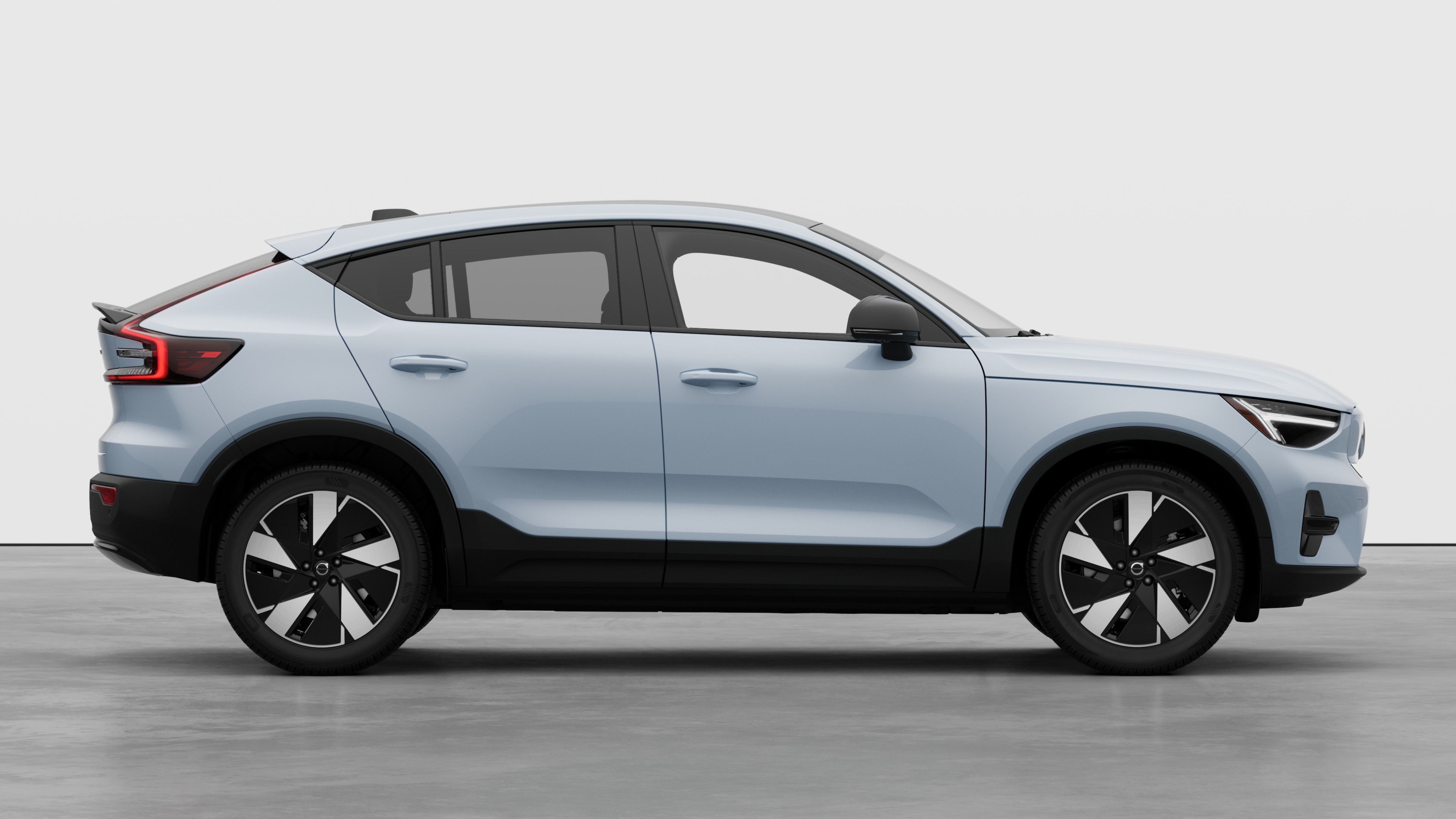 Volvo car side view on plain studio background displaying closed doors and visible wheel design.