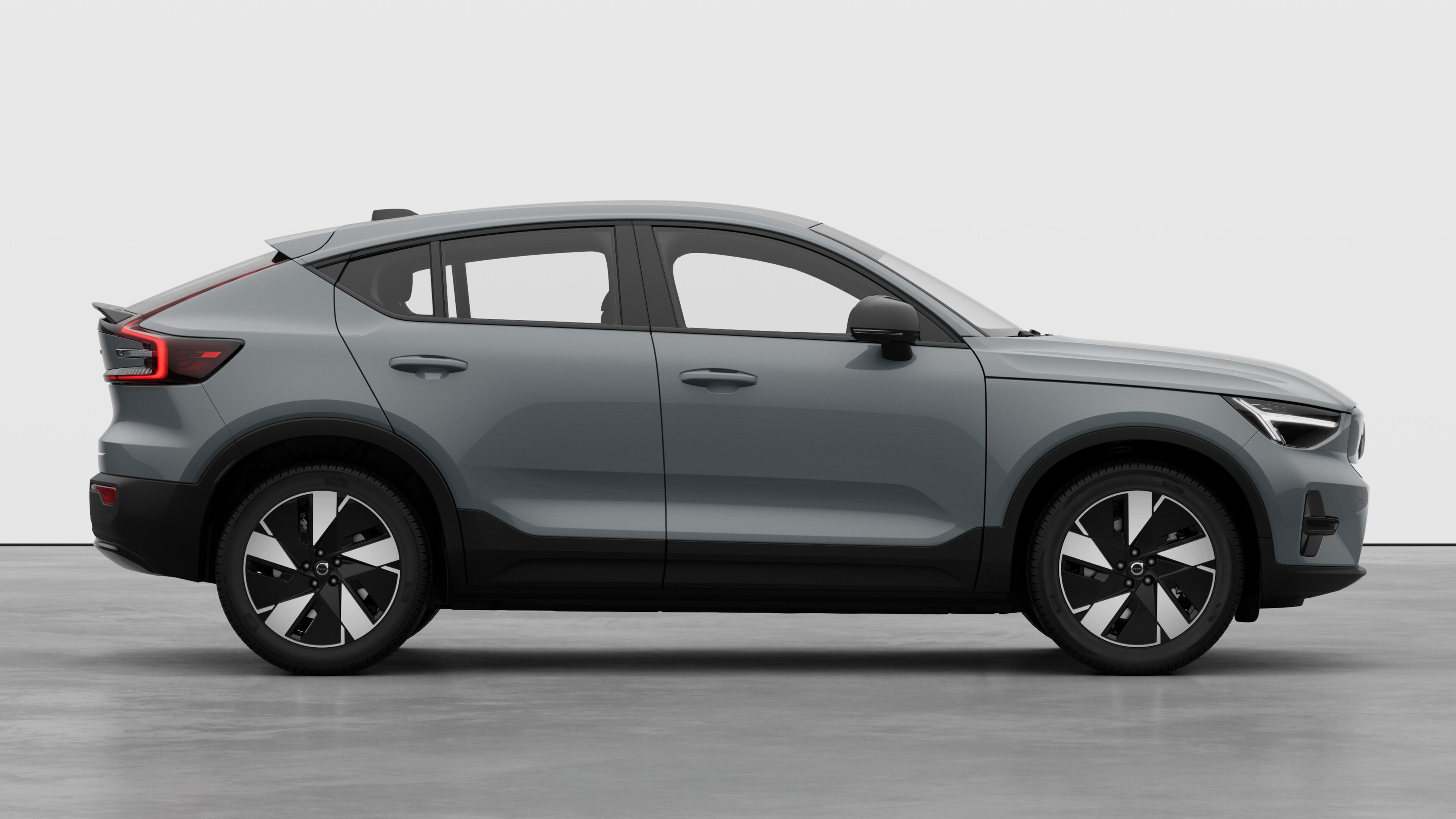 Zijaanzicht van een Volvo op een eenvoudige studioachtergrond met gesloten deuren en zichtbaar wielontwerp.