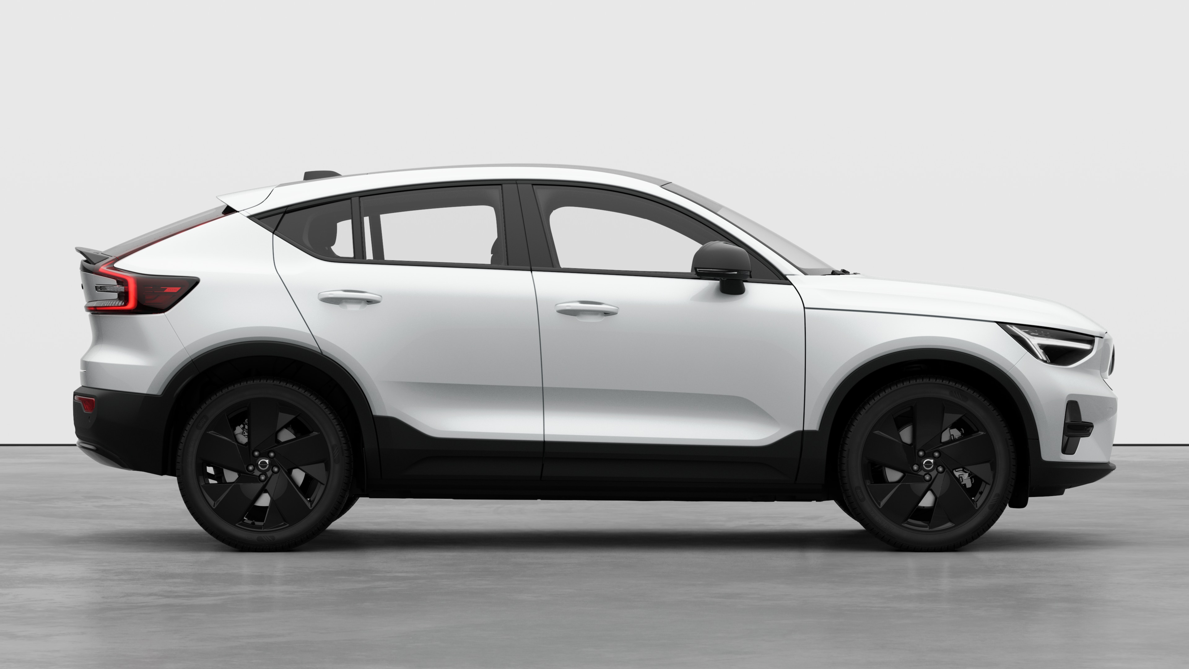 Seitenansicht eines Volvo Fahrzeugs auf einem schlichten Studiohintergrund mit geschlossenen Türen und sichtbarem Raddesign.