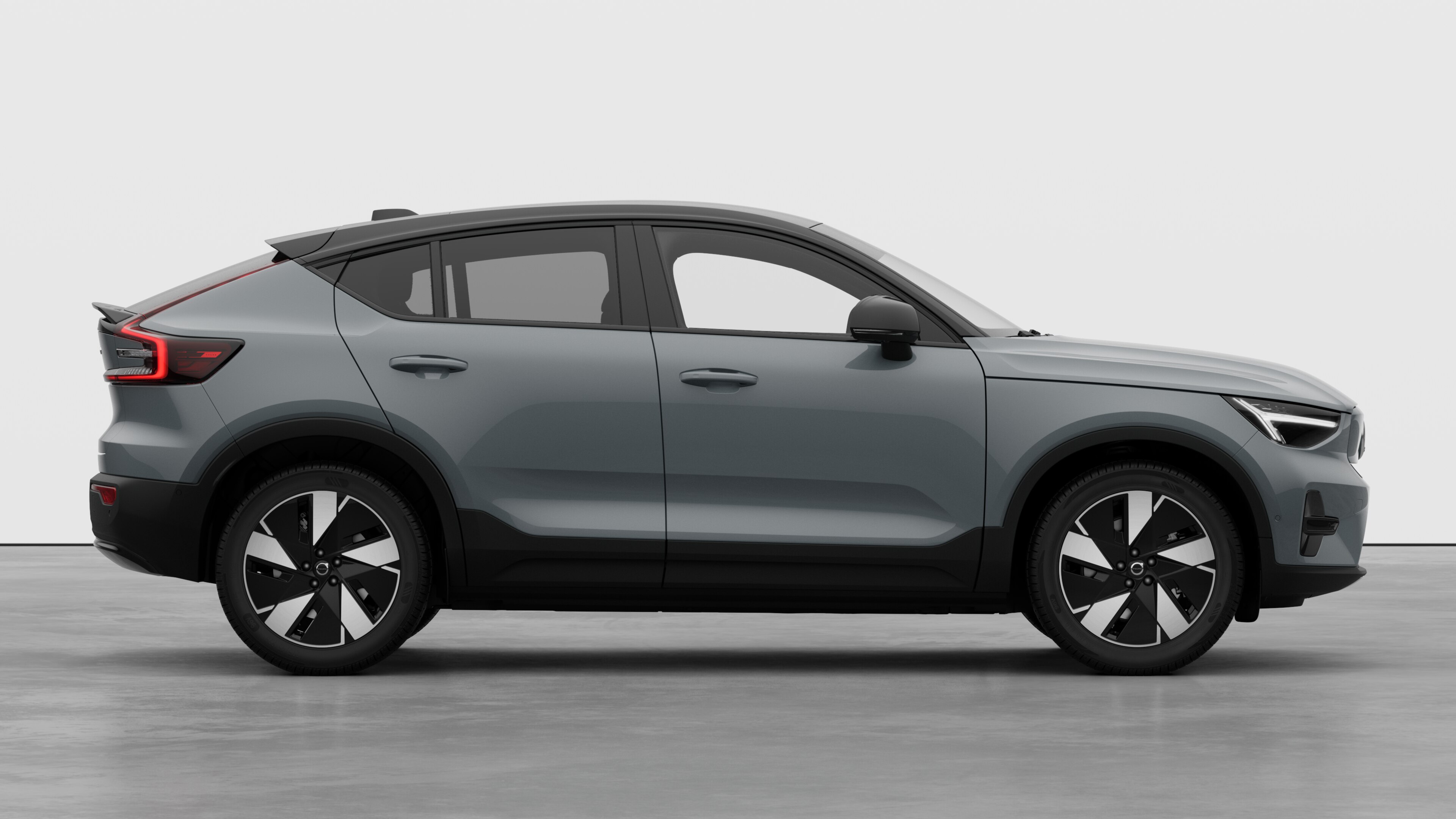 Zijaanzicht van een Volvo op een eenvoudige studioachtergrond met gesloten deuren en zichtbaar wielontwerp.