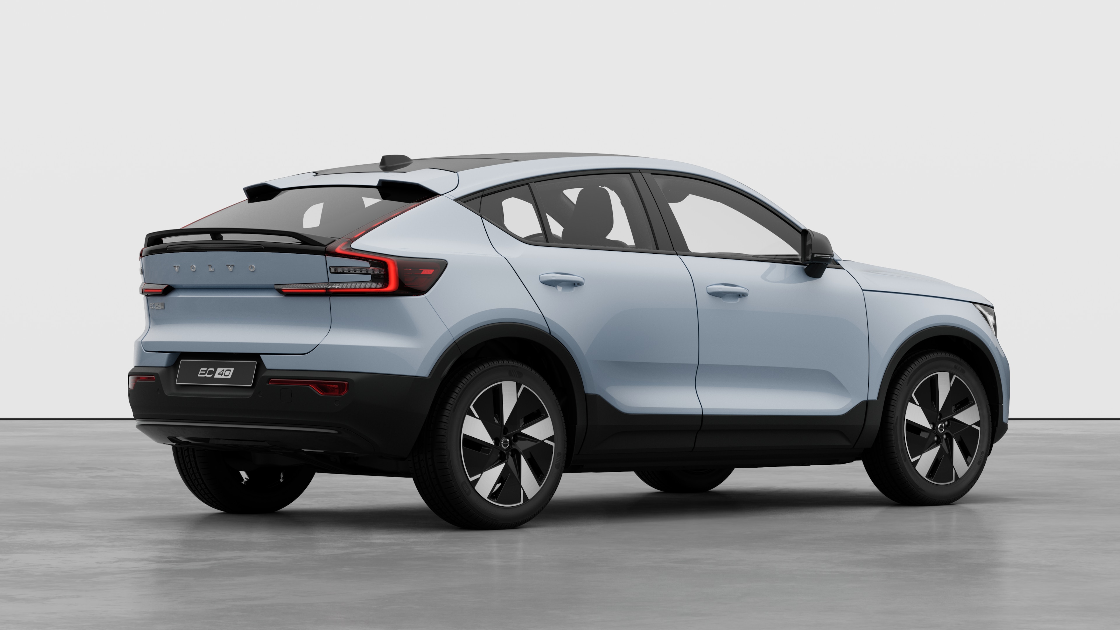 Заден изглед от три четвърти на автомобил Volvo на обикновен студиен фон.