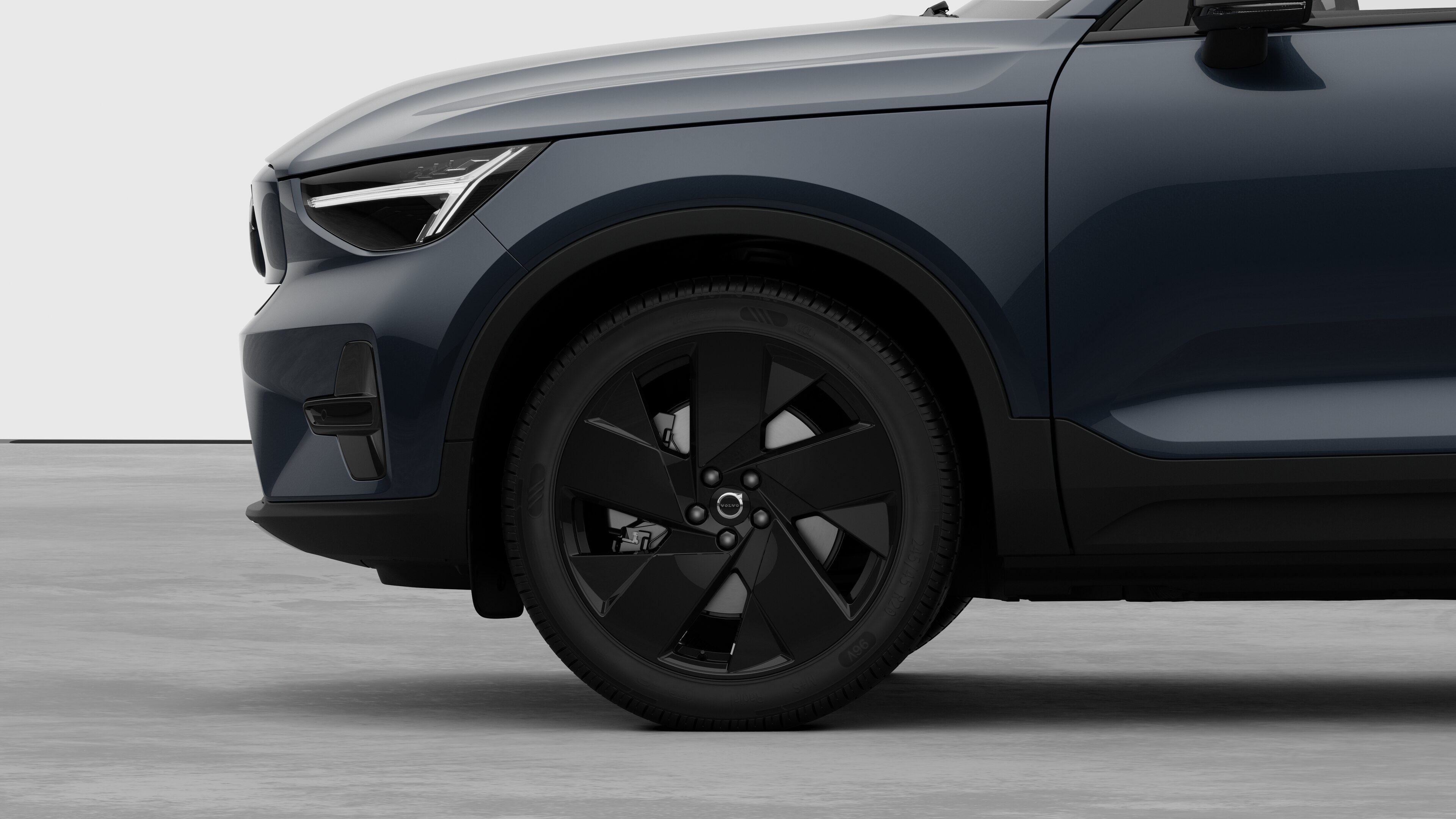 Seitenansicht eines Volvo Fahrzeugs mit Fokus auf Vorderrad und Kotflügel vor einem schlichten Studiohintergrund.