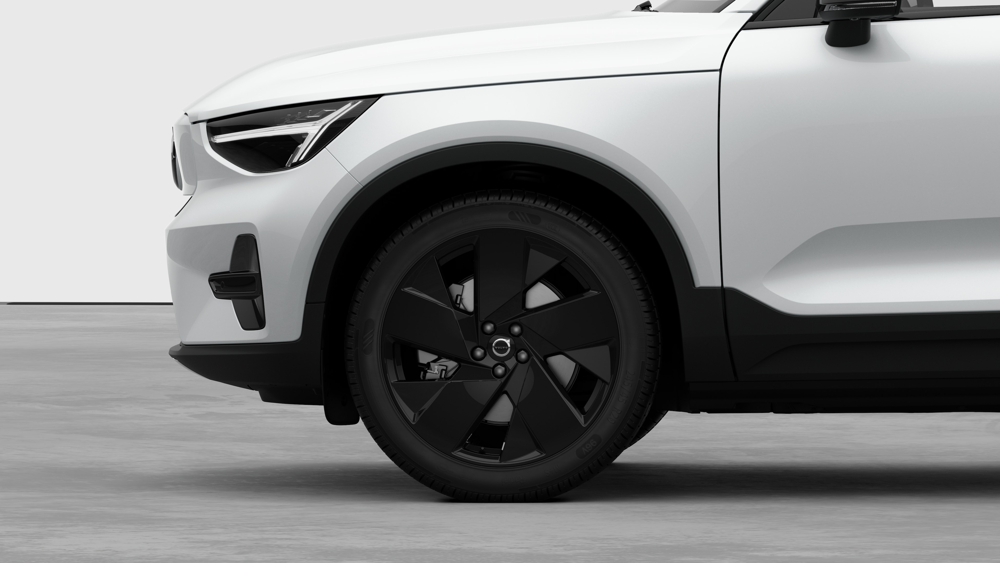 Seitenansicht eines Volvo Fahrzeugs mit Fokus auf Vorderrad und Kotflügel vor einem schlichten Studiohintergrund.