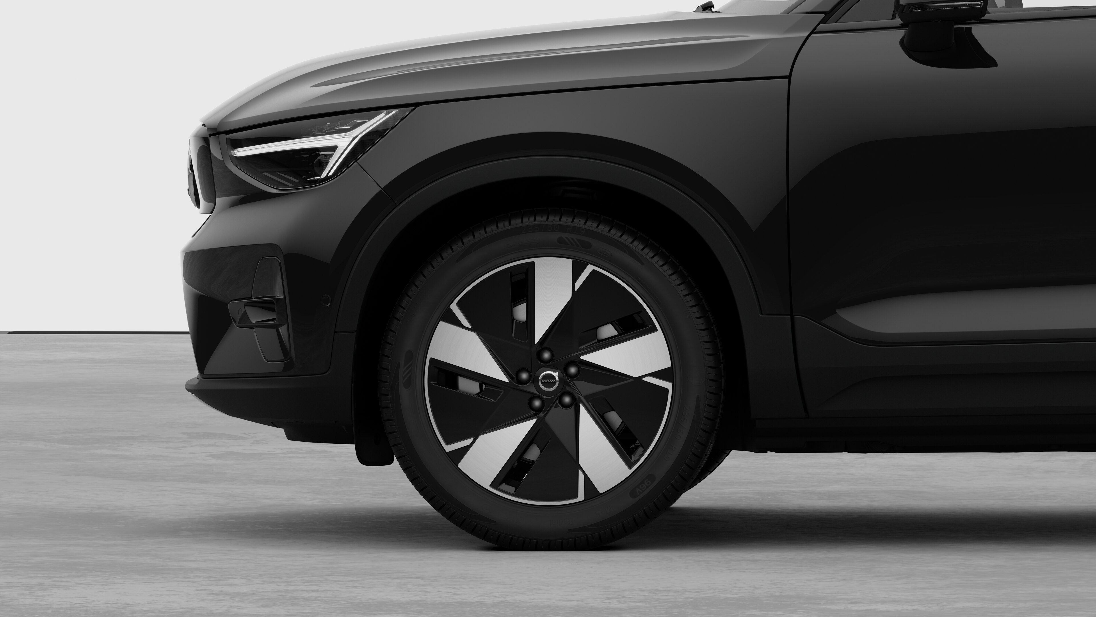 Hình ảnh bên ngoài xe Volvo tập trung vào bánh trước và chắn bùn, đặt trên nền studio đơn giản.