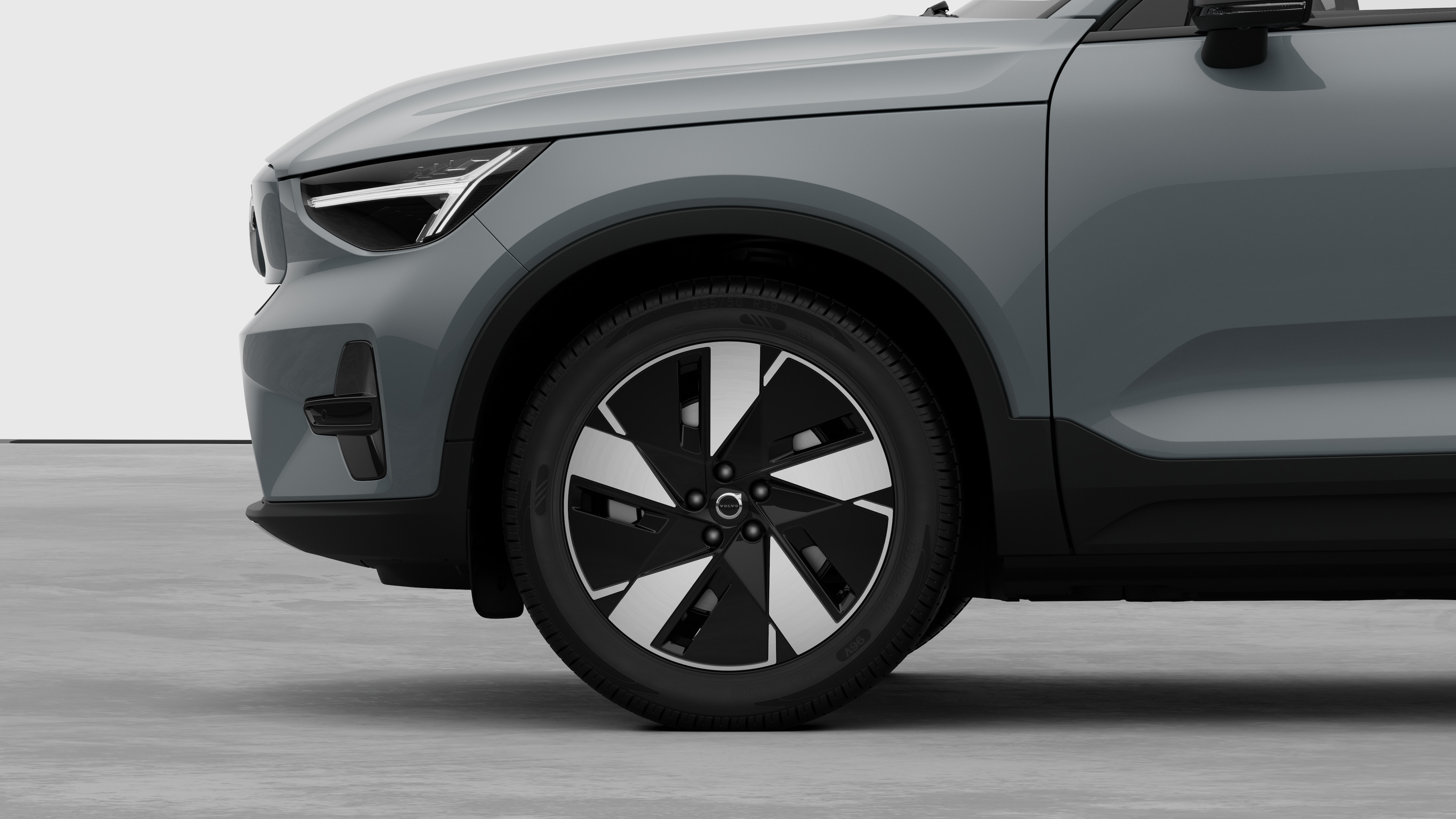 Vue latérale extérieure de la Volvo se concentrant sur la roue avant et l’aile, sur un fond de studio uni.