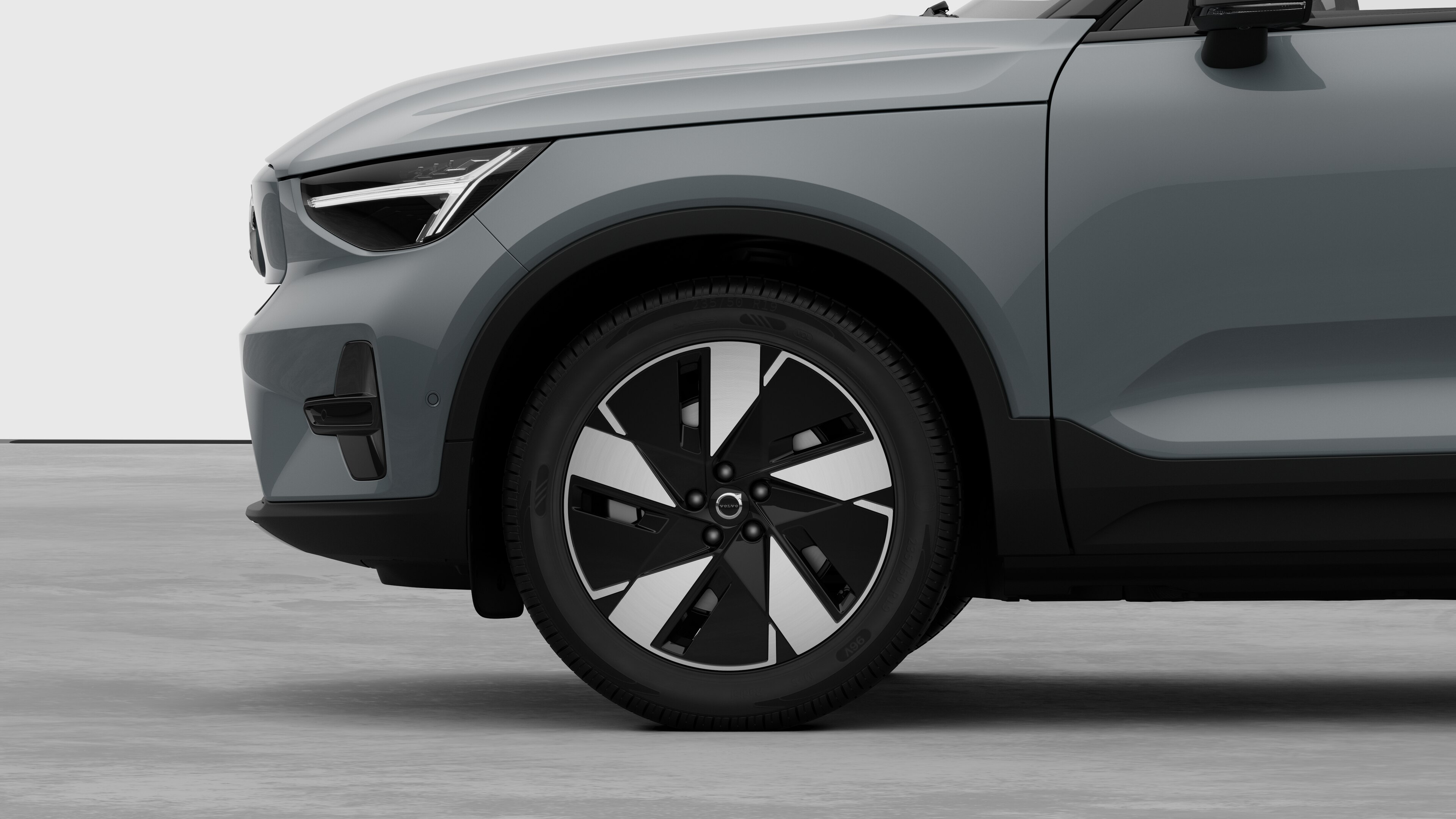 Vue latérale extérieure de la Volvo se concentrant sur la roue avant et l’aile, sur un fond de studio uni.