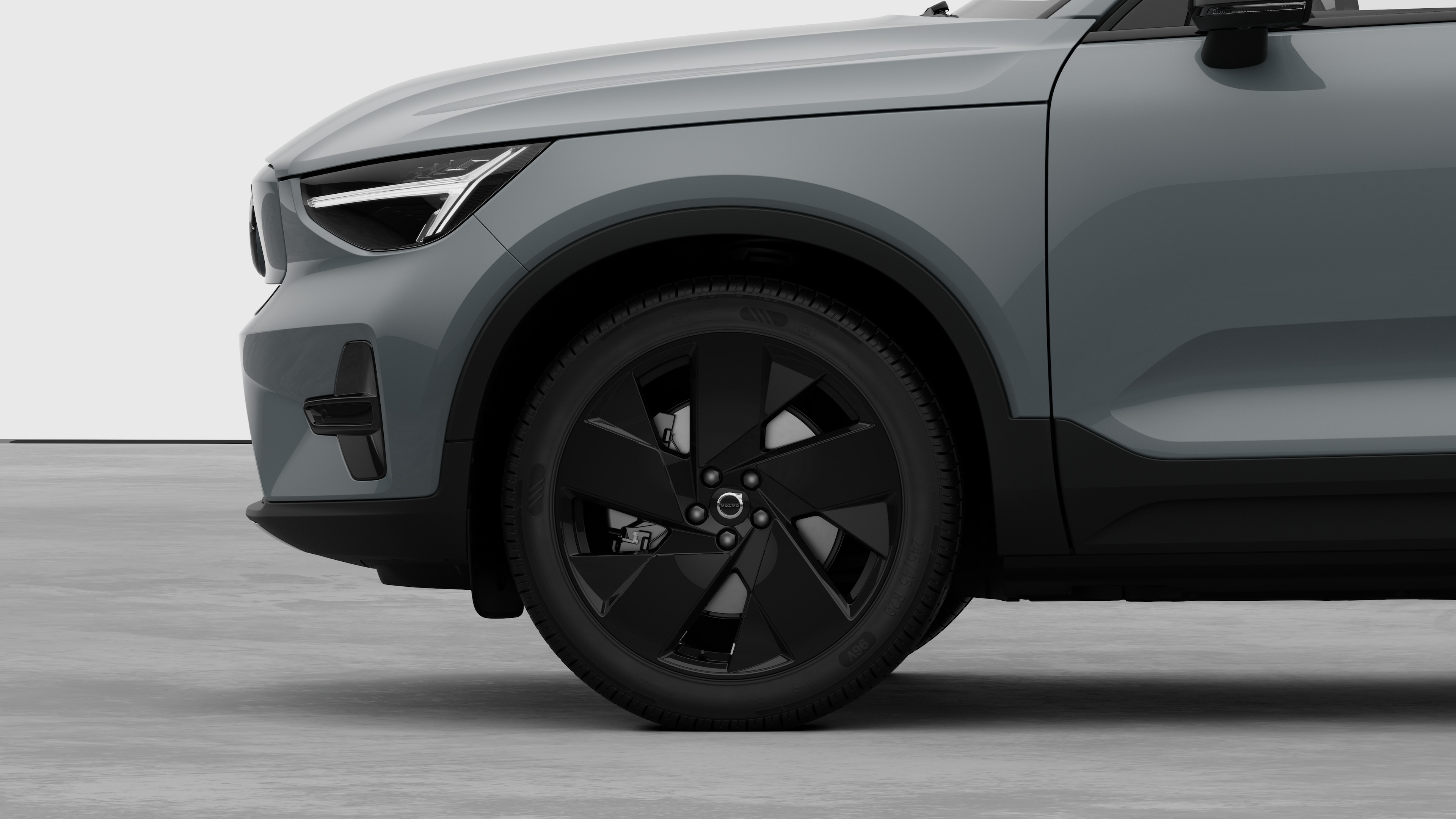 Seitenansicht eines Volvo Fahrzeugs mit Fokus auf Vorderrad und Kotflügel vor einem schlichten Studiohintergrund.