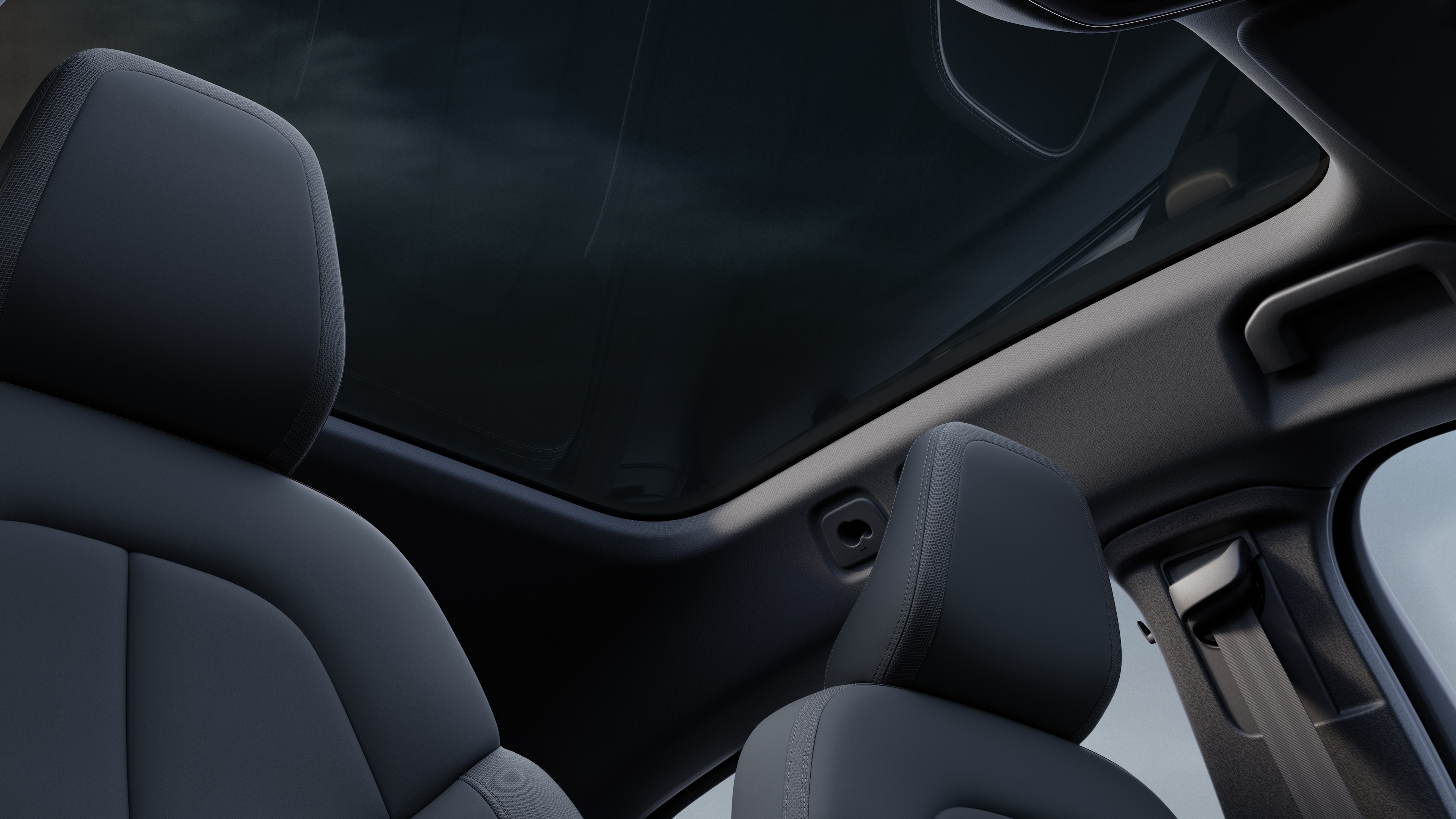 Volvo car interior showing front and rear passenger seats, steering wheel, dashboard, and center console against a plain studio background.